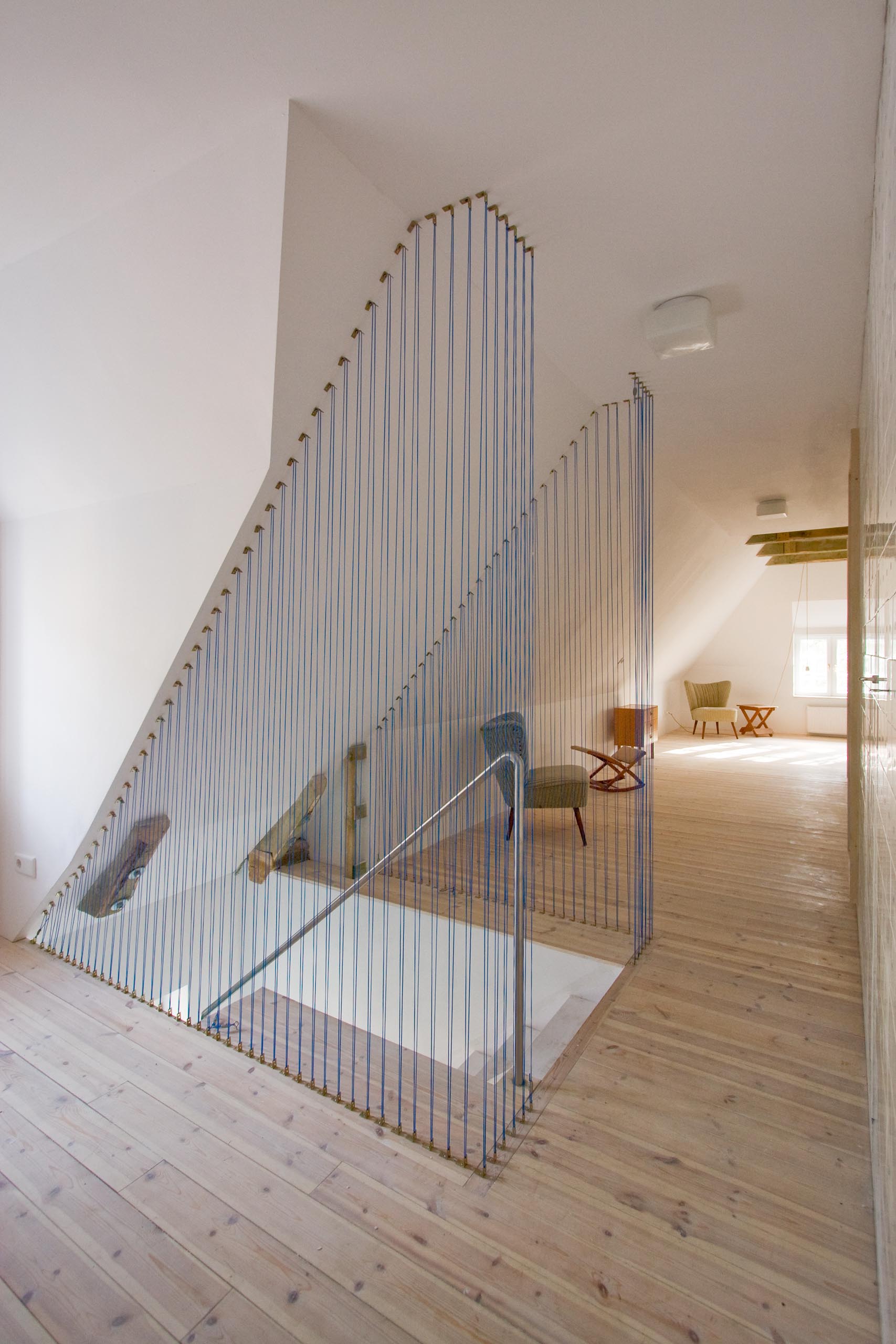 Modern stairs with a blue rope safety barrier.