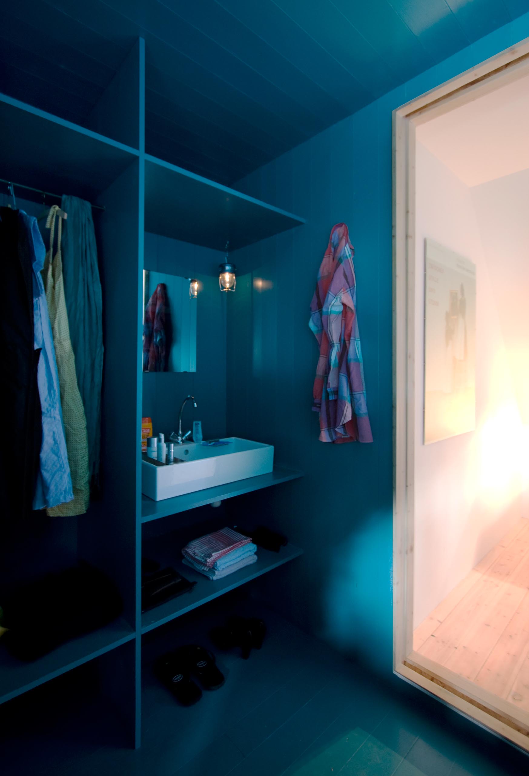 A modern turquoise blue closet that includes a vanity.