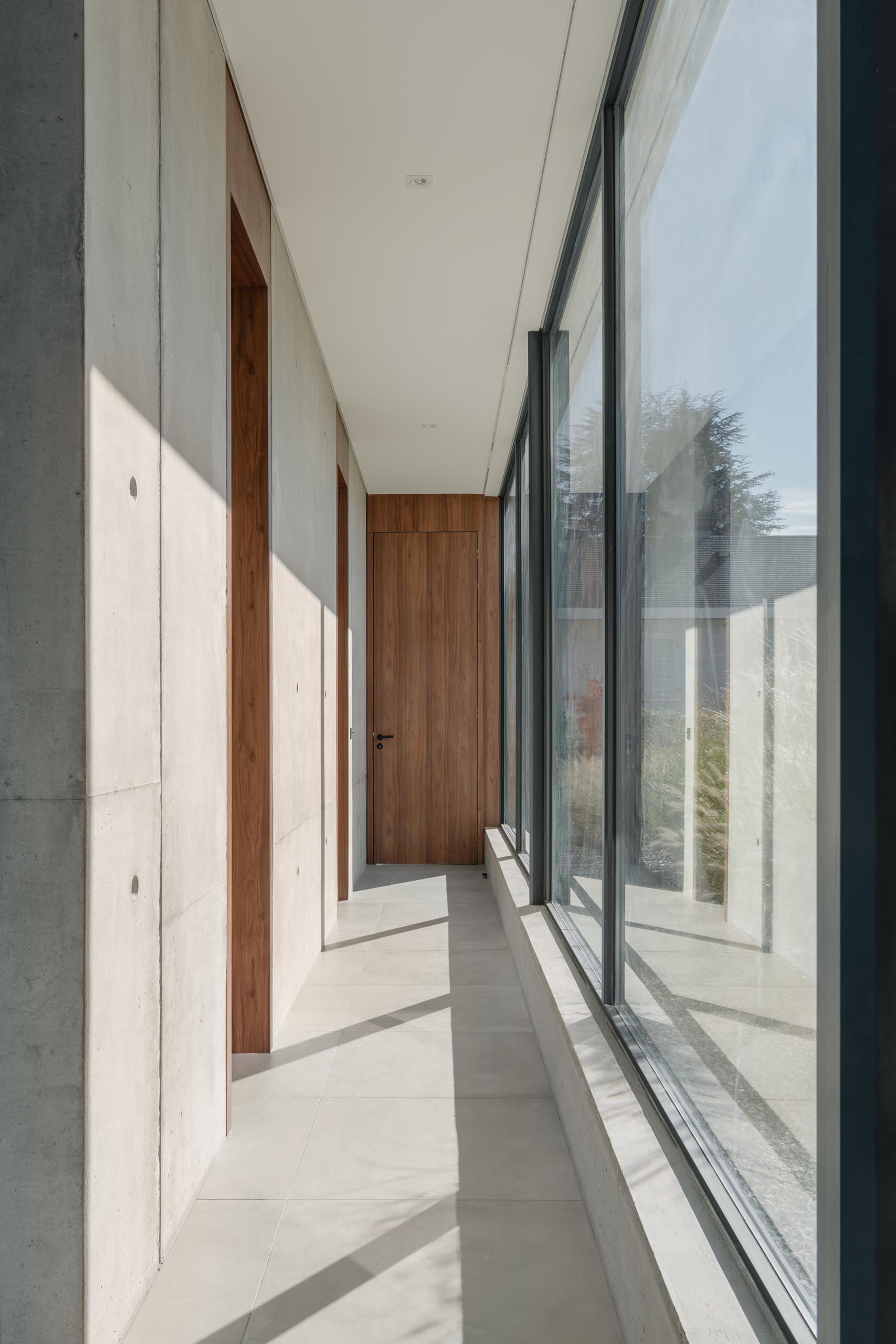 Floor-to-ceiling windows line this modern hallway and add plenty of natural light.