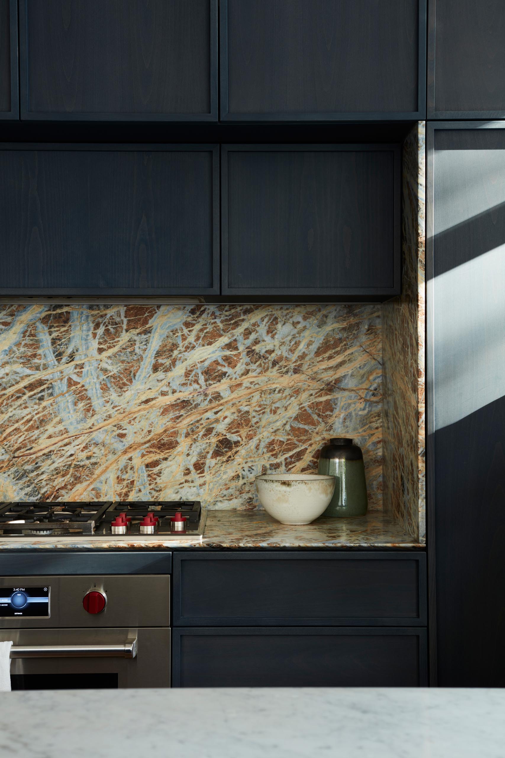 A modern kitchen with dark hardware free cabinets.