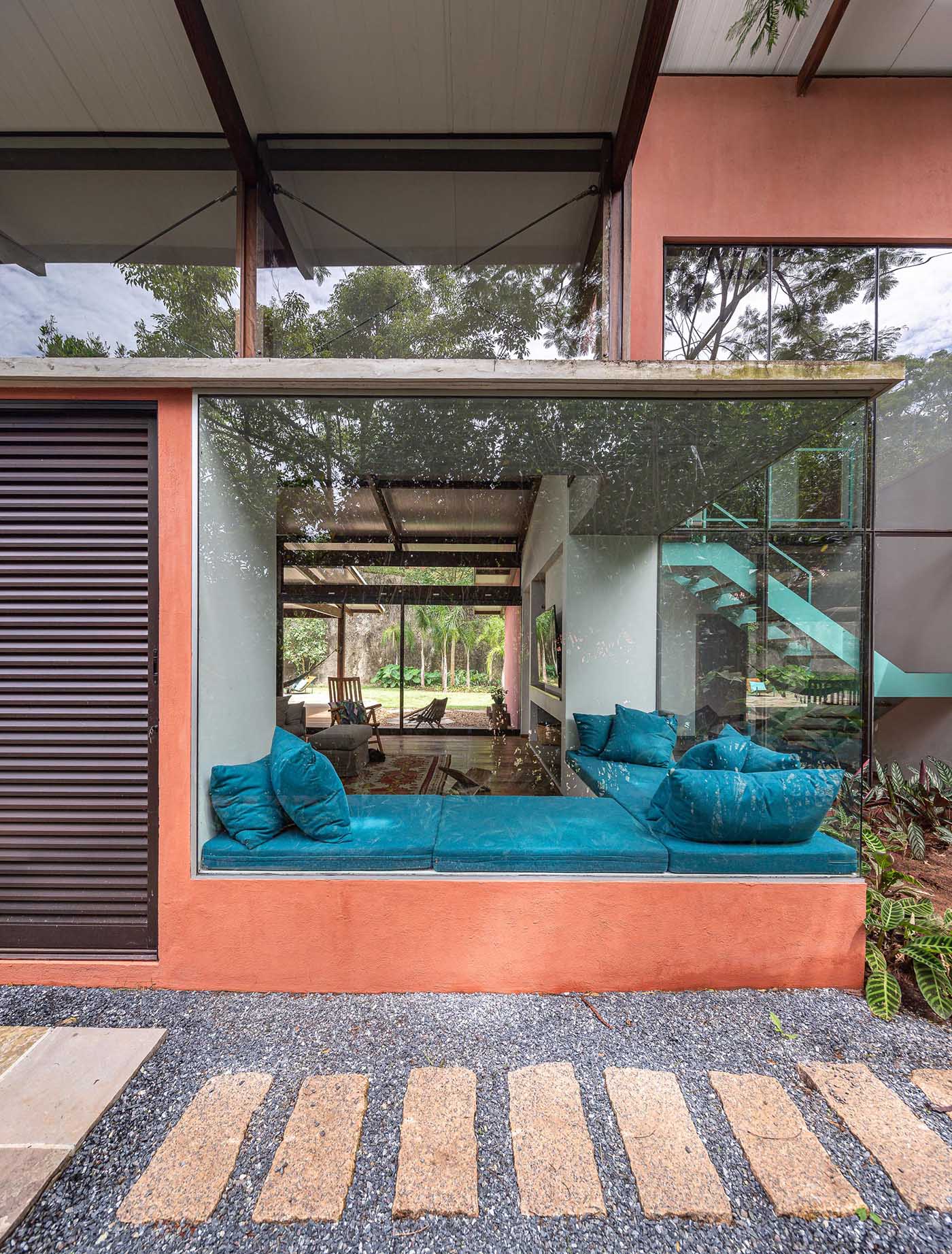 This modern window bench makes its home next to large windows and has has a height that matches the bottom of the glass, which can been seen from the exterior of the home.