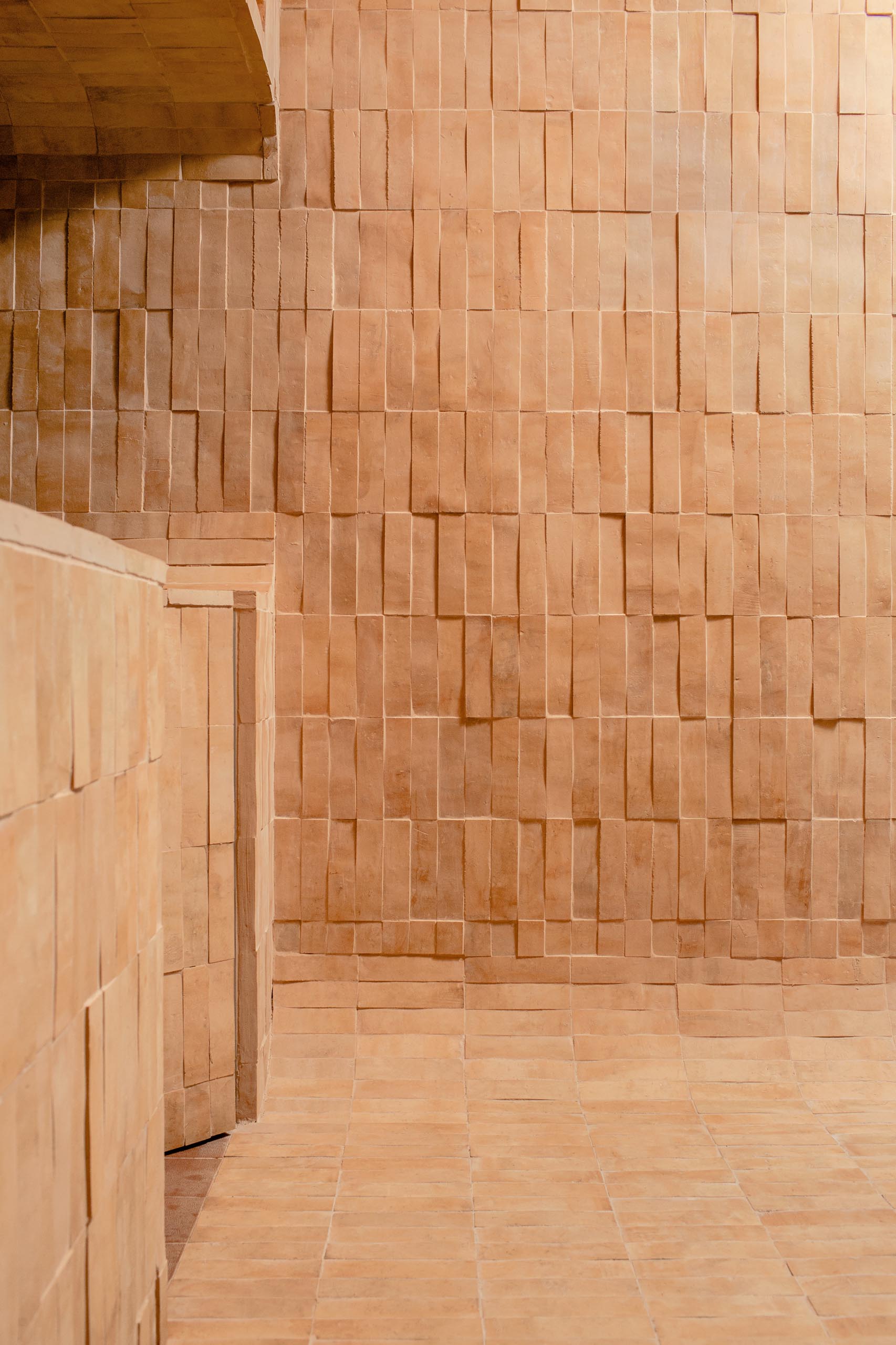 Earth colored tiles line the walls as well as the floor and the service area of this modern bubble tea cafe.