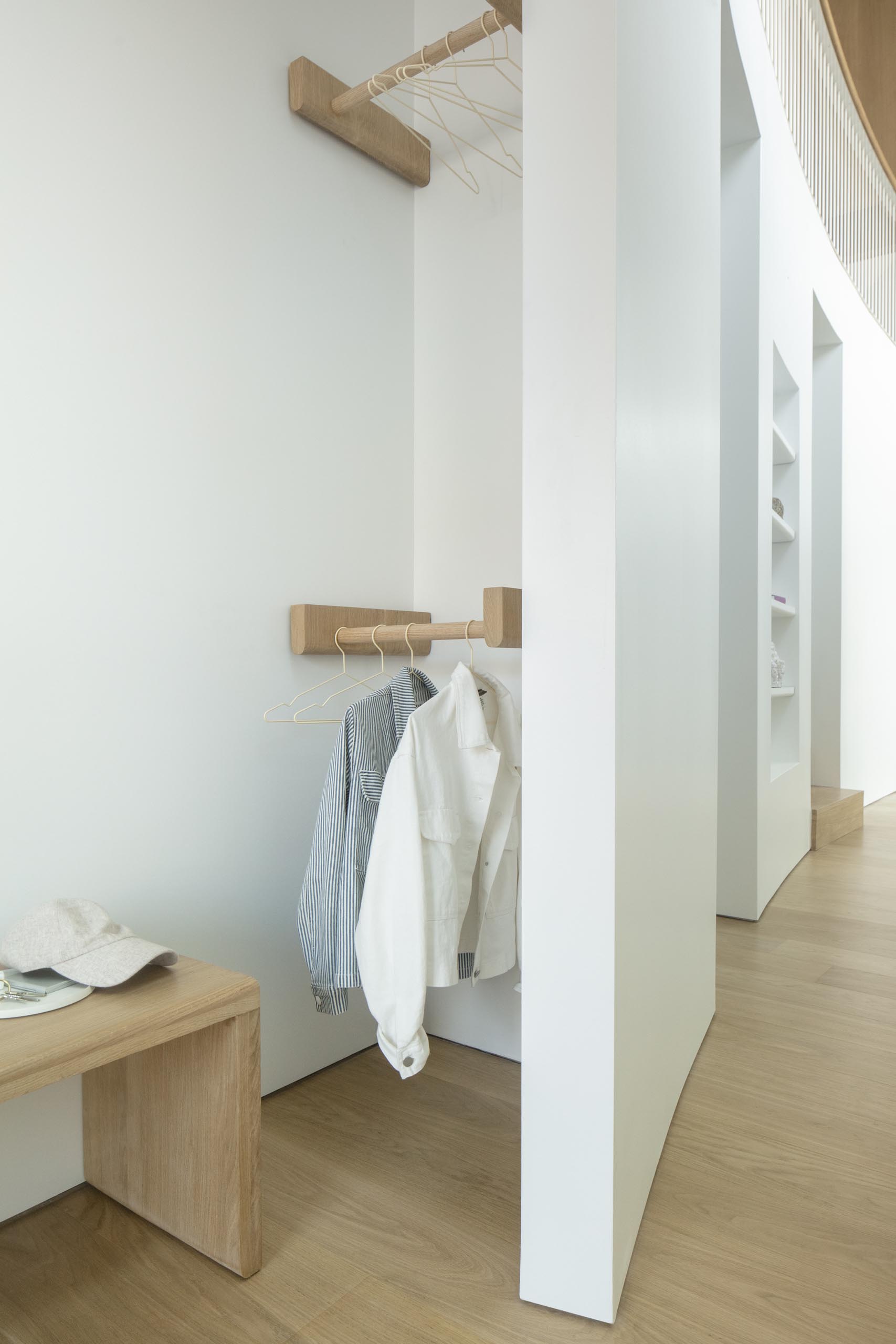 This modern home features a curved double-height atrium with seating, built-in closet, and a reading nook.