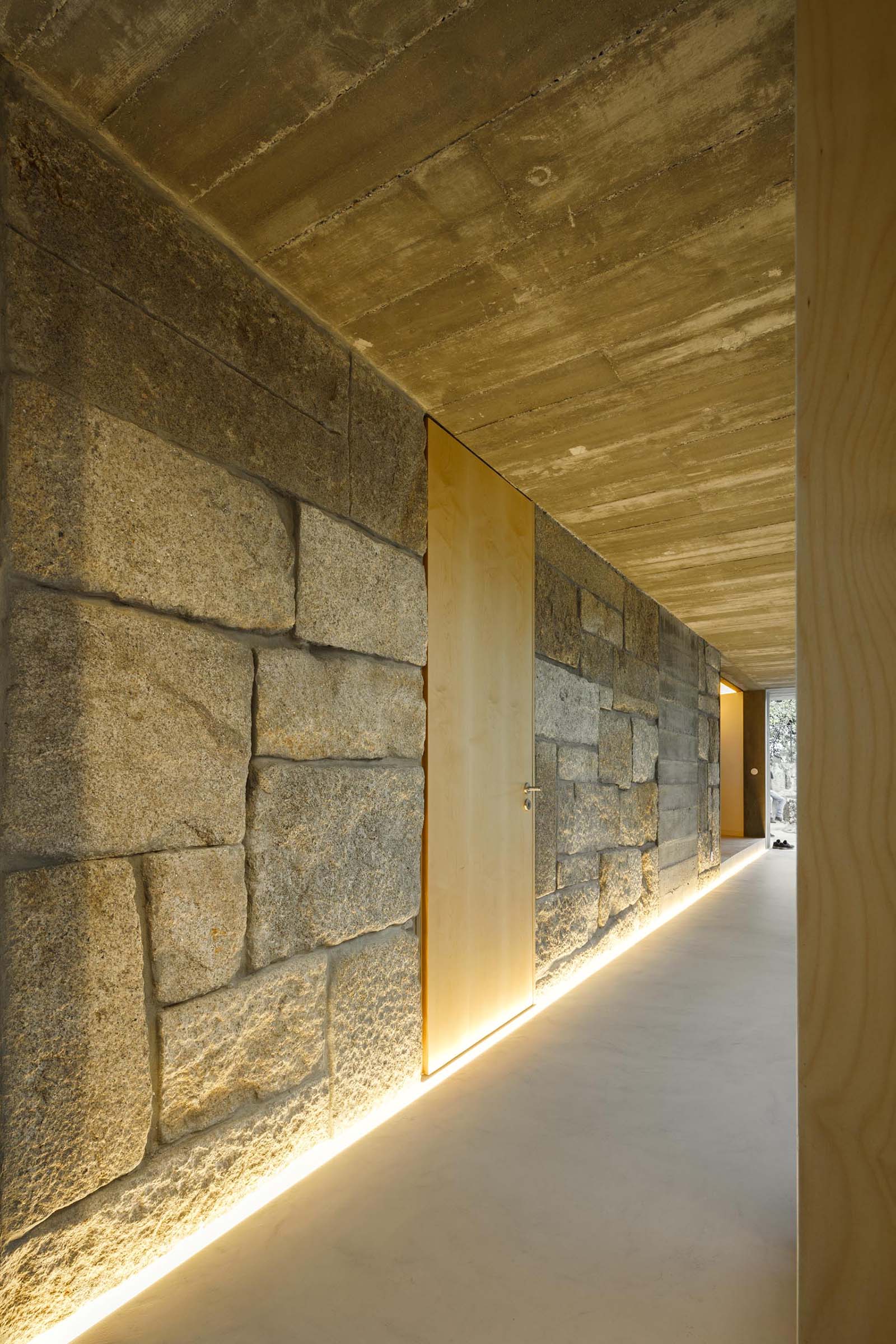 By using illuminated LED strips, the stone, concrete, and wood walls throughout this modern home are able to be showcased in a subtle way.