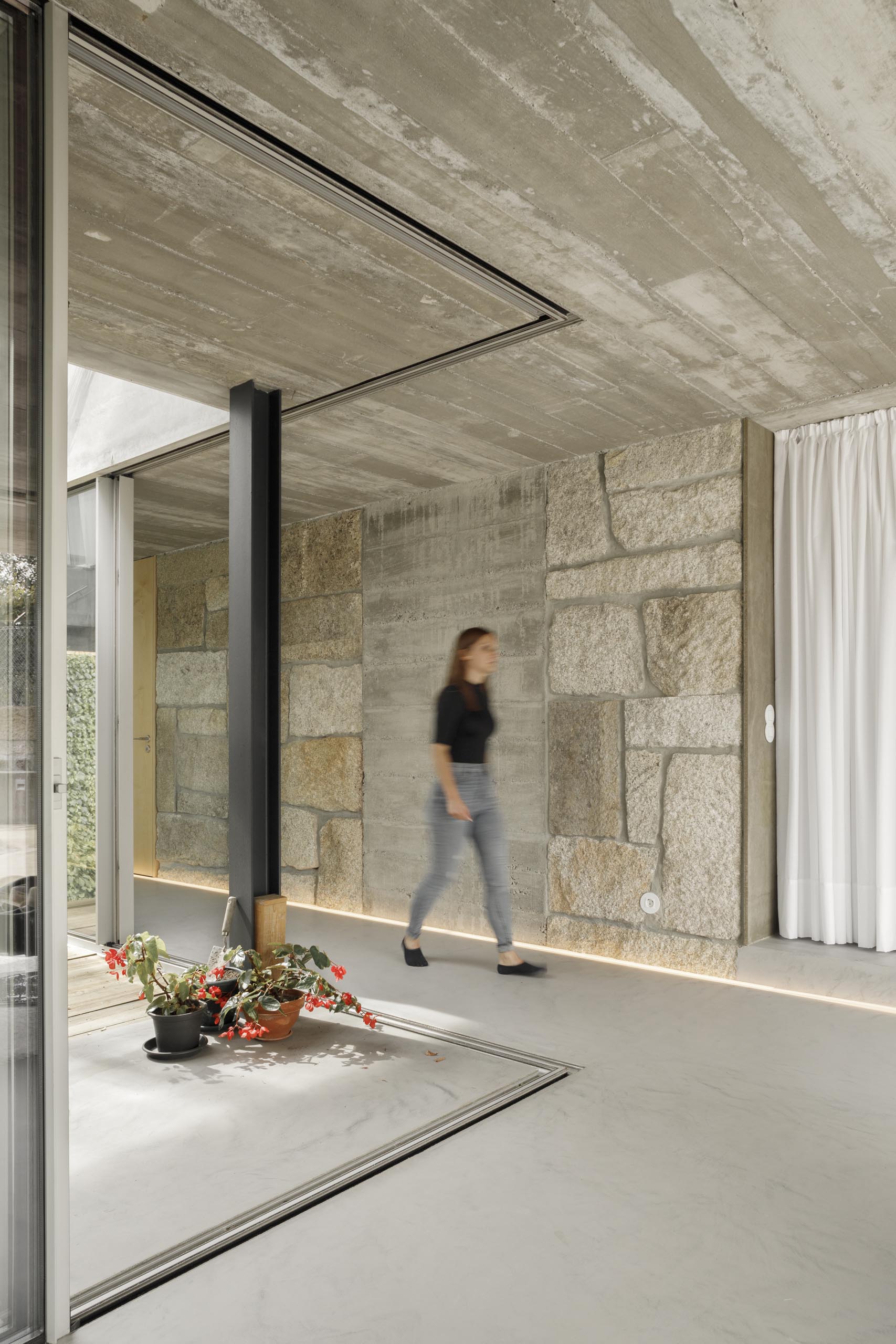 Bằng cách sử dụng các dải đèn LED chiếu sáng, các bức tường bằng đá, bê tông và gỗ trong ngôi nhà hiện đại này có thể được thể hiện một cách tinh tế.