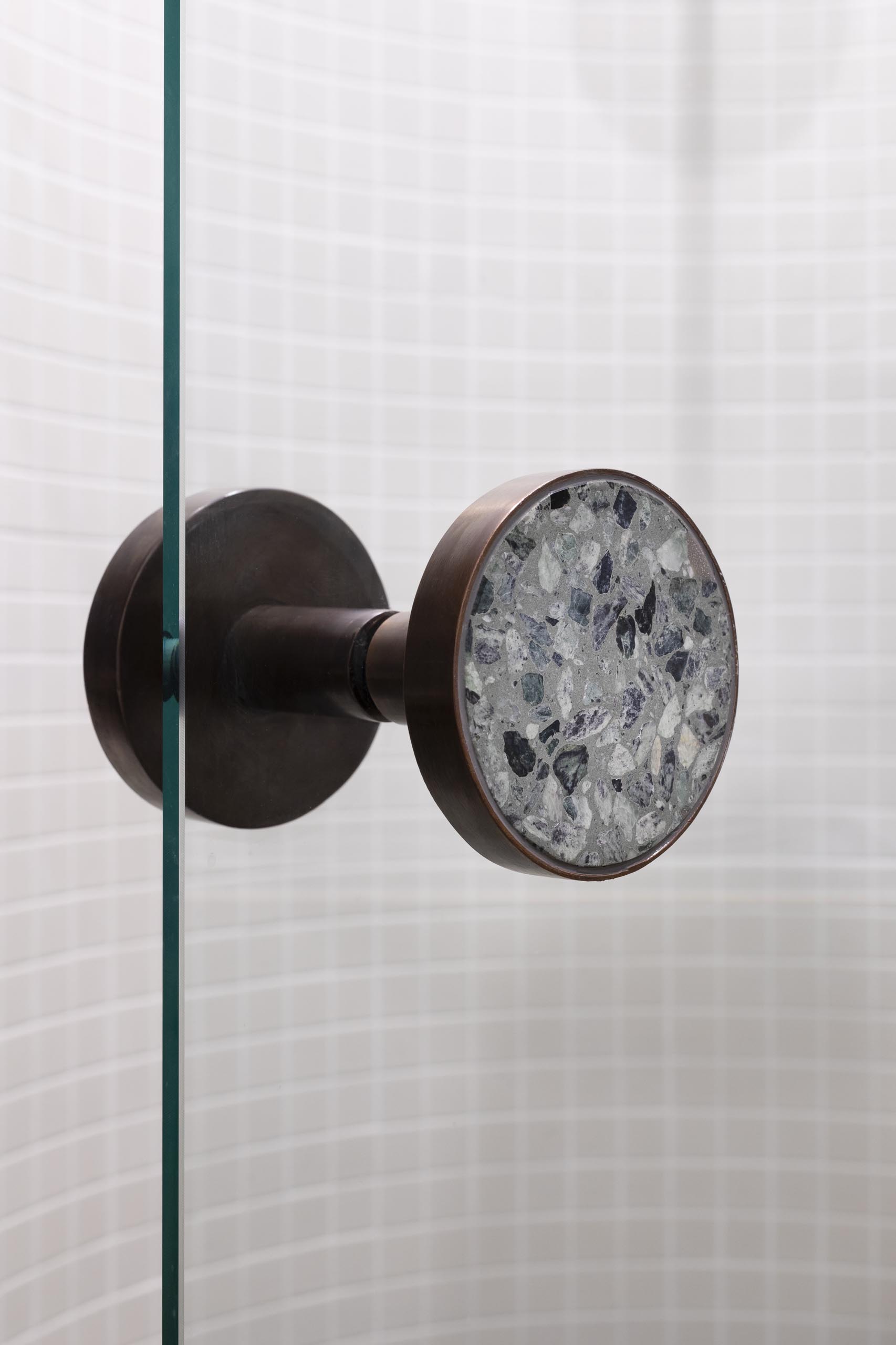 A glass shower screen with bronze hardware.