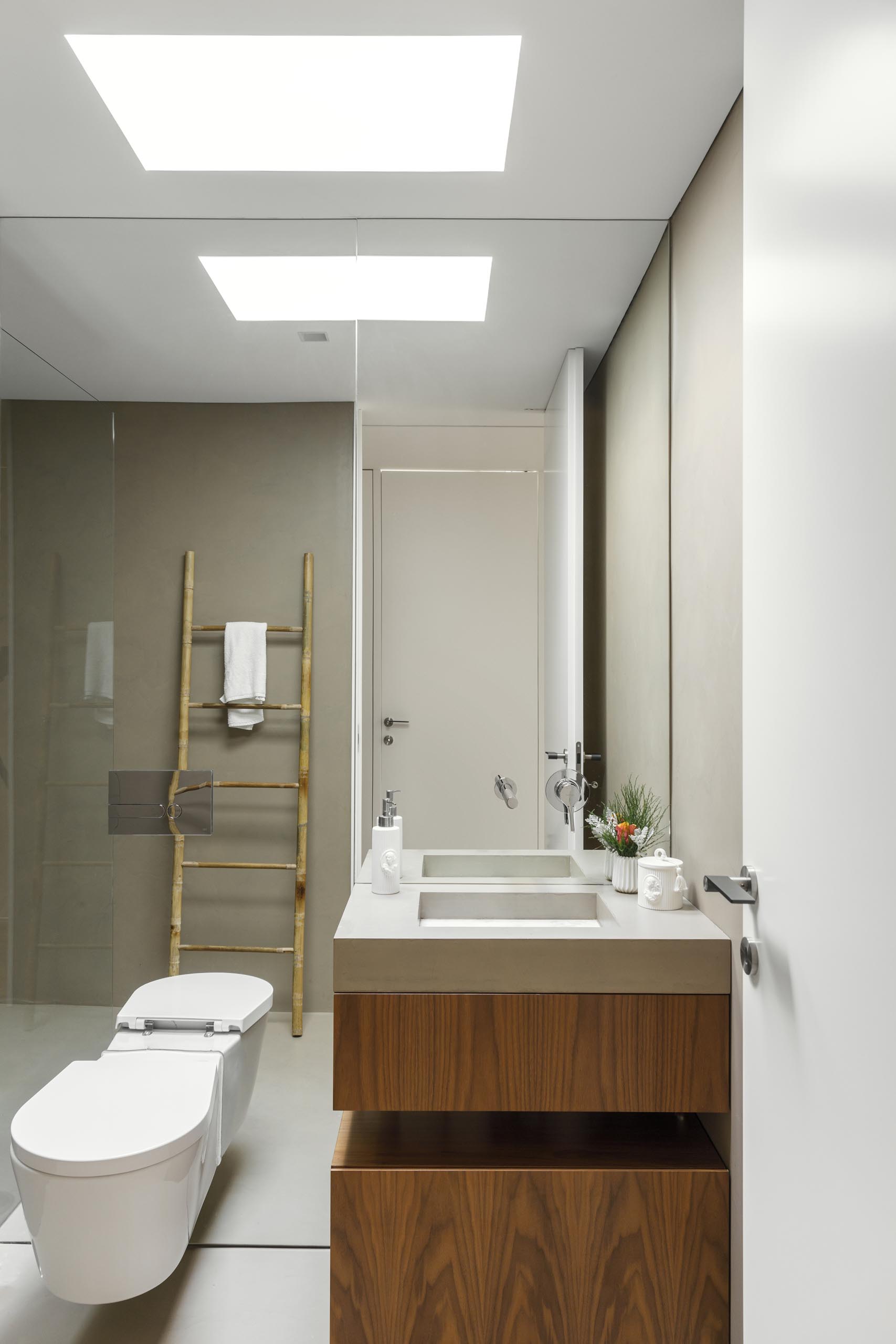 A modern bathroom with a built-in vanity sink and a floor-to-ceiling mirror.