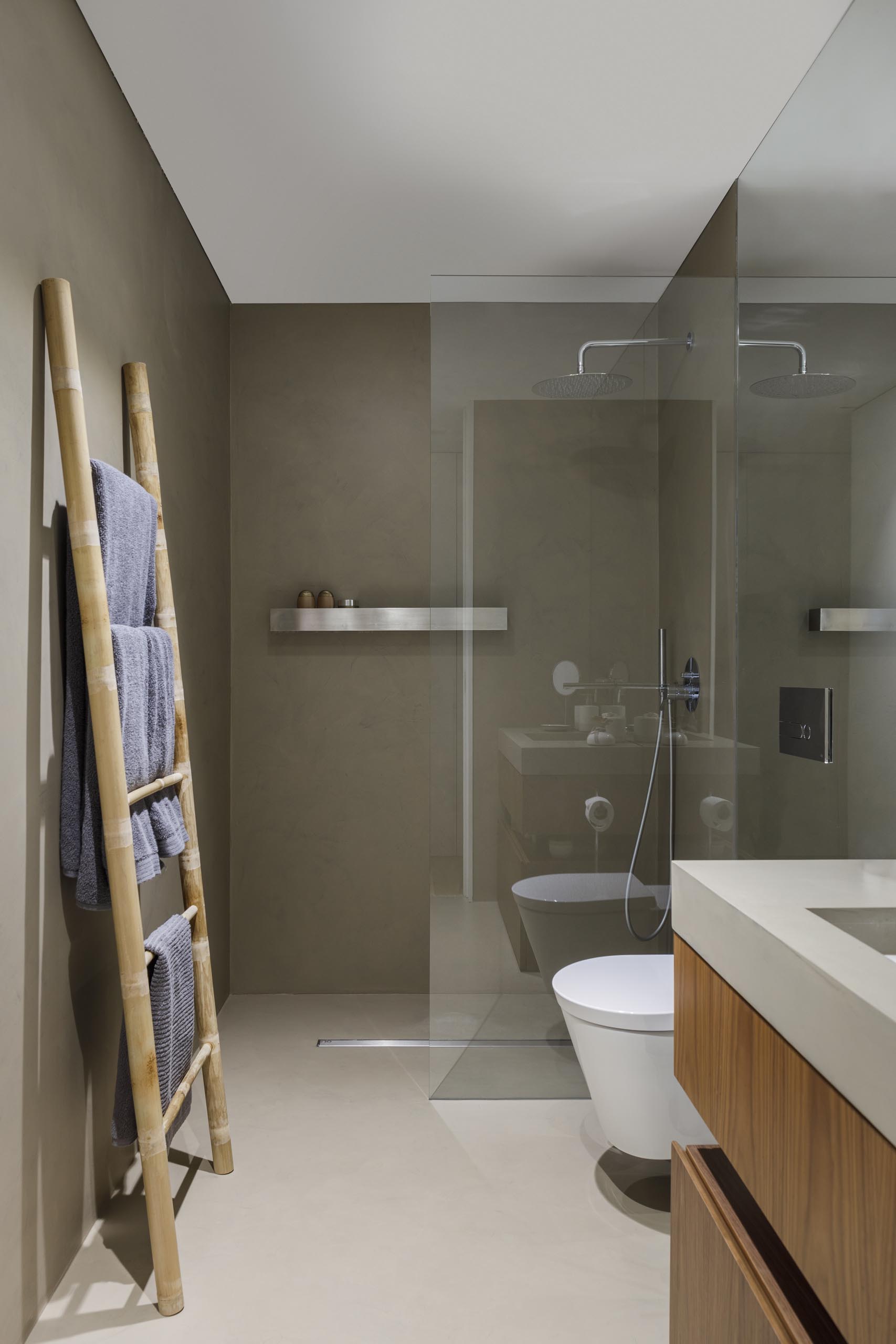 A modern bathroom with a floating shelf in the shower.