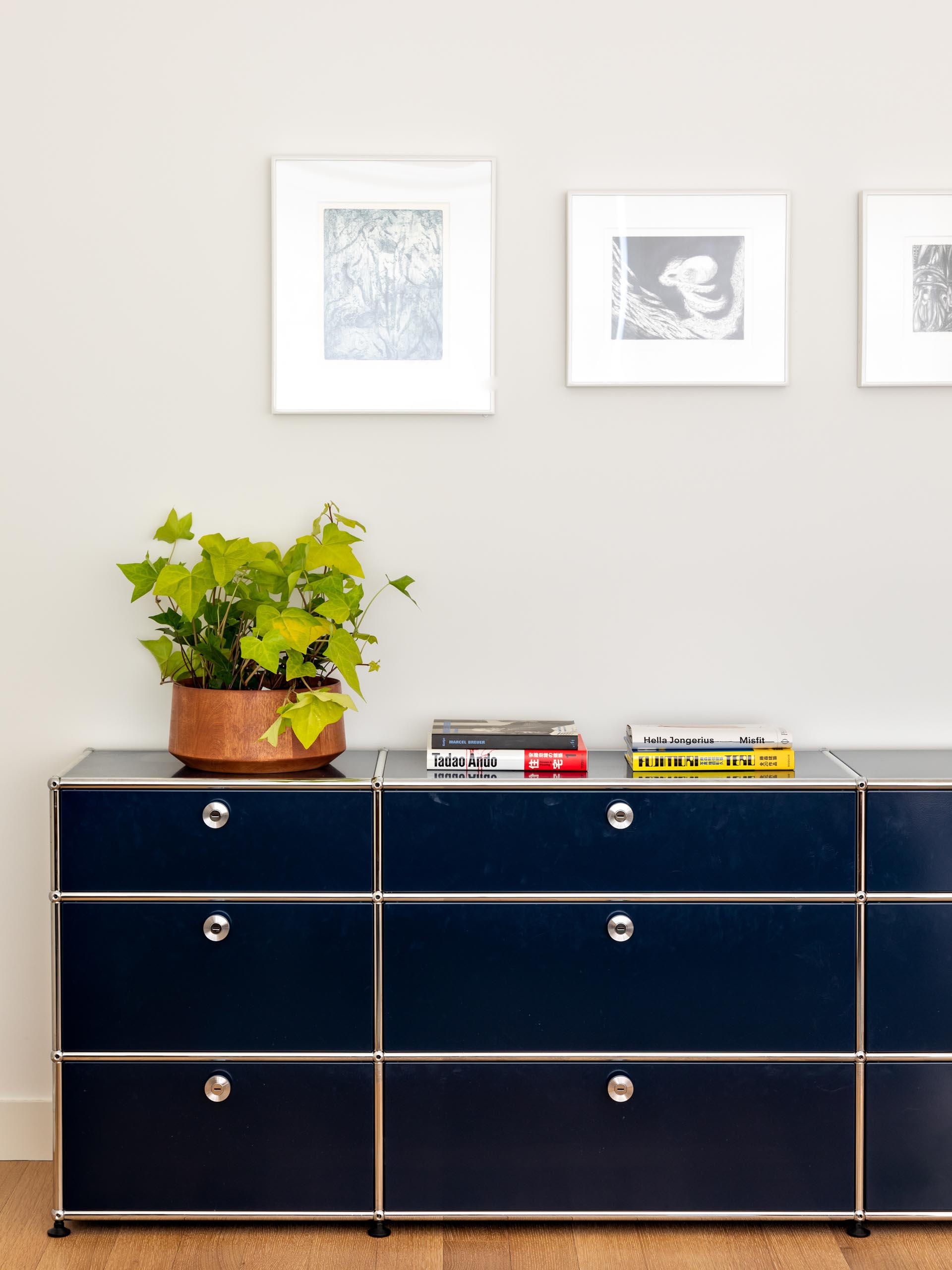 A modern master bedroom that includes wood furniture, pops of color, and a graphic accent wall.