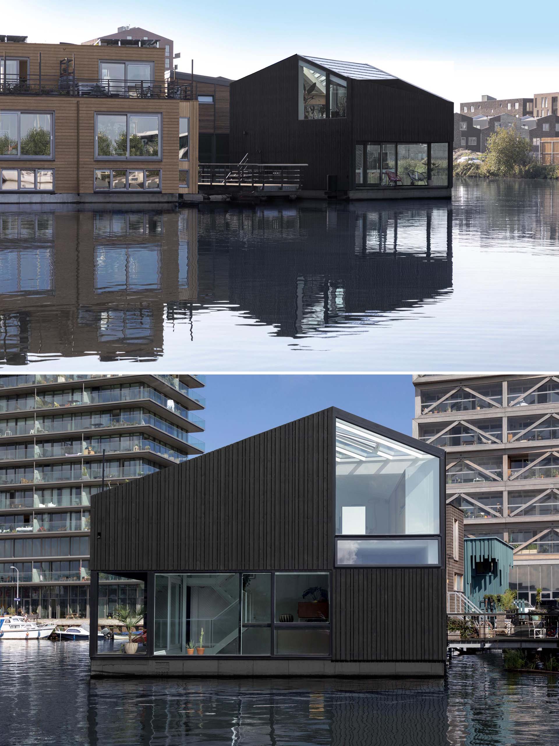 A modern float home with black wood siding.