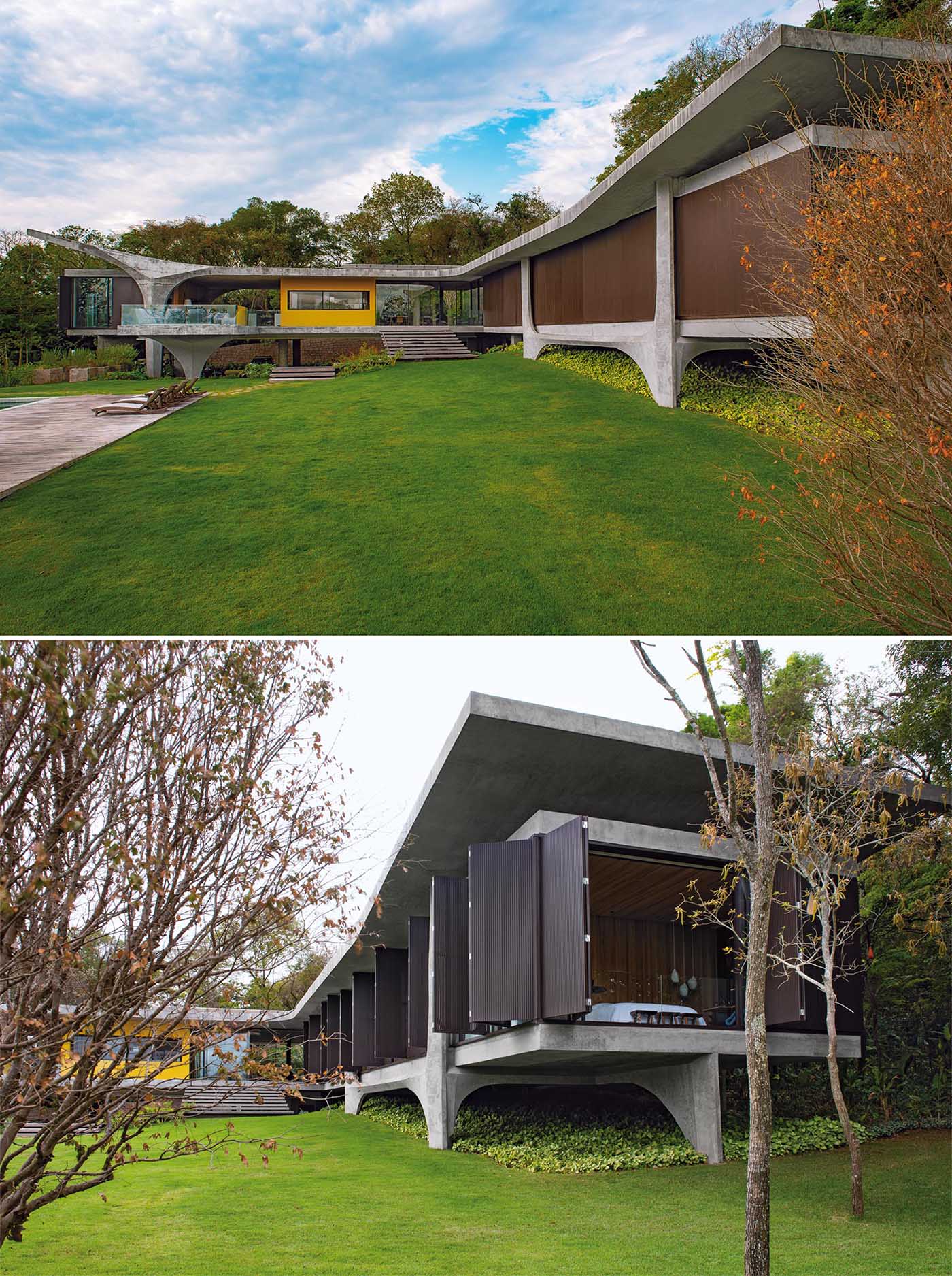 The design of this modern concrete house allows the form to somewhat appear as though it floats over the terrain, while the pillars add a sculptural element.