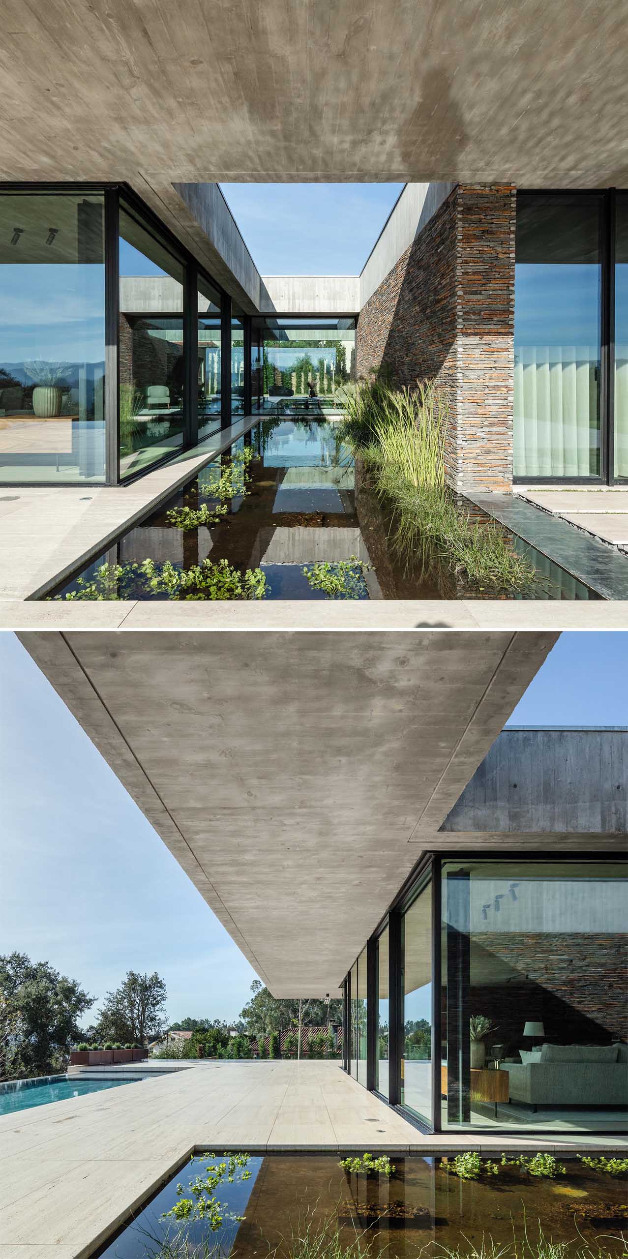A modern concrete home with glass walls and a water feature.