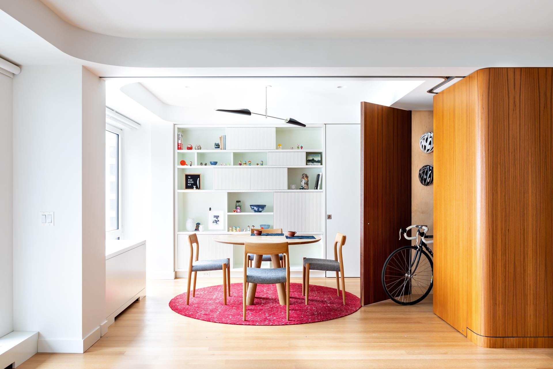 This modern apartment has a teak cube that's been designed with a door that opens to a storage room.