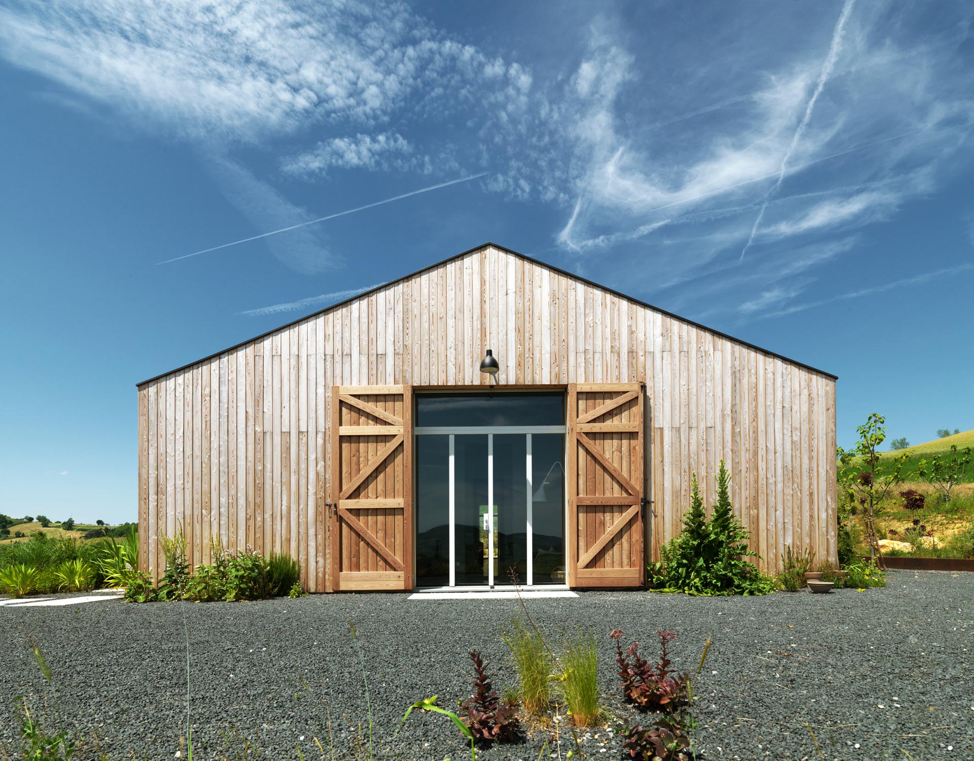 The exterior of this modern farmhouse is clad with natural larch wood and shutters.