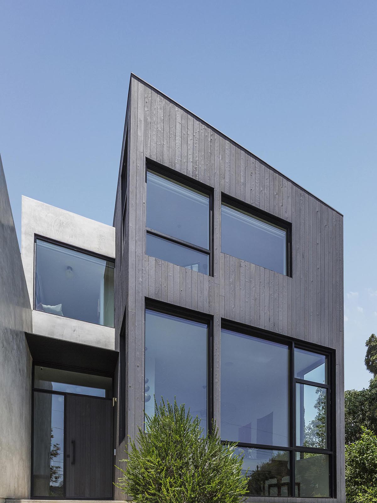 A modern house with Shou Sugi Ban charred cypress wood and a smooth exterior plaster.