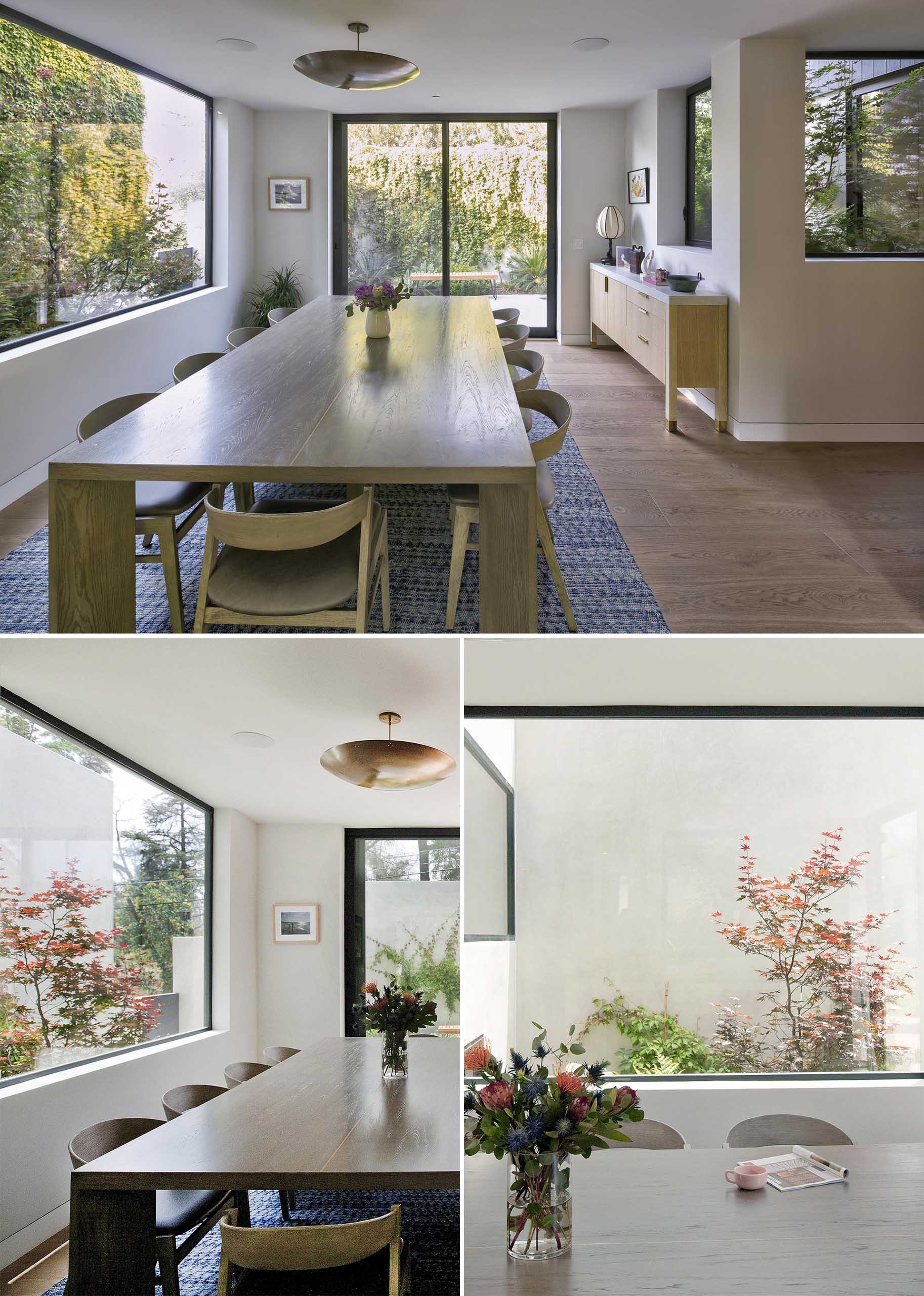 This modern dining room has a large wood table with a single pendant light overhead.