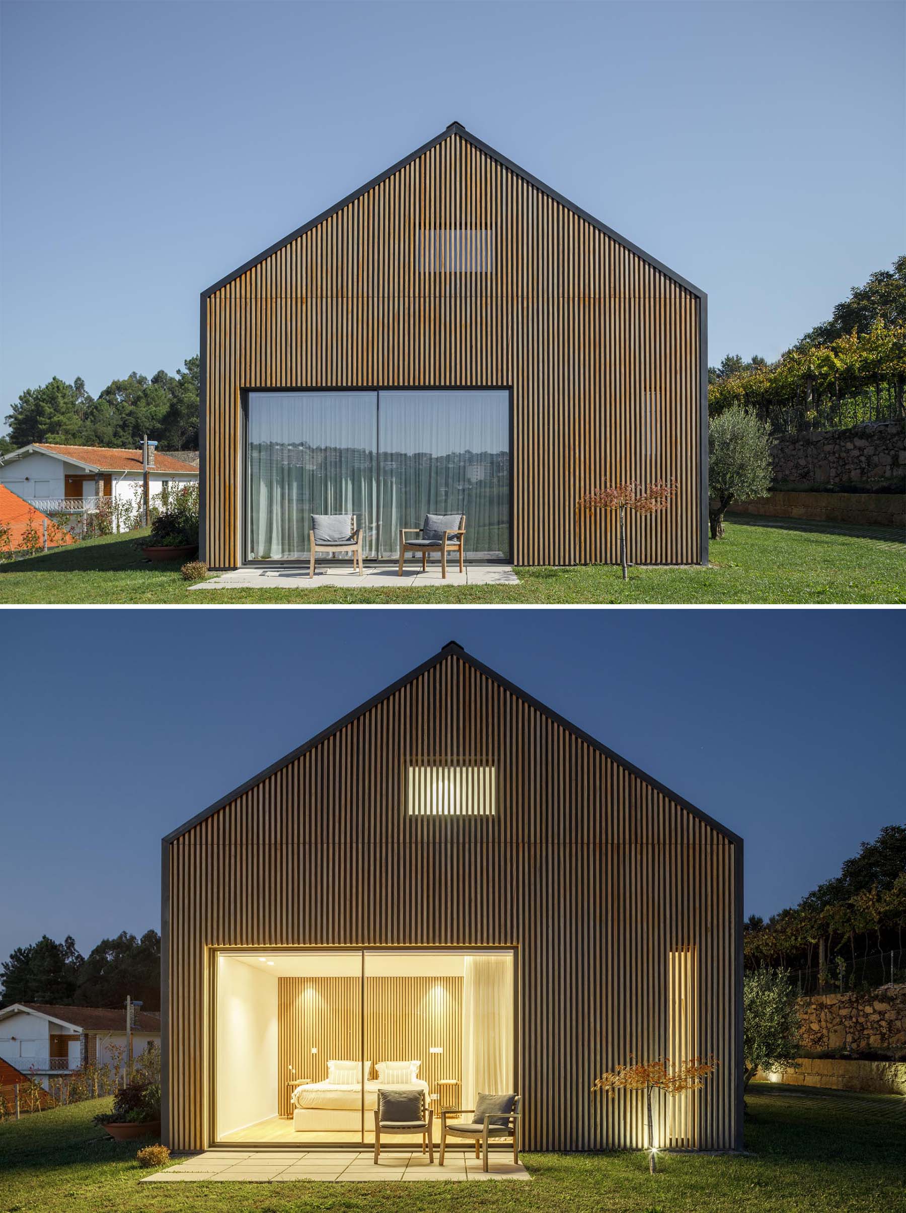 A modern home with a wood slat wall that somewhat hides a pair of windows.