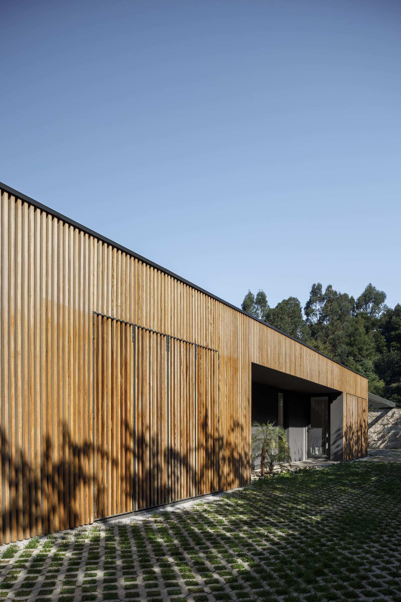 A modern home with a large window from view with a wood slat wall.