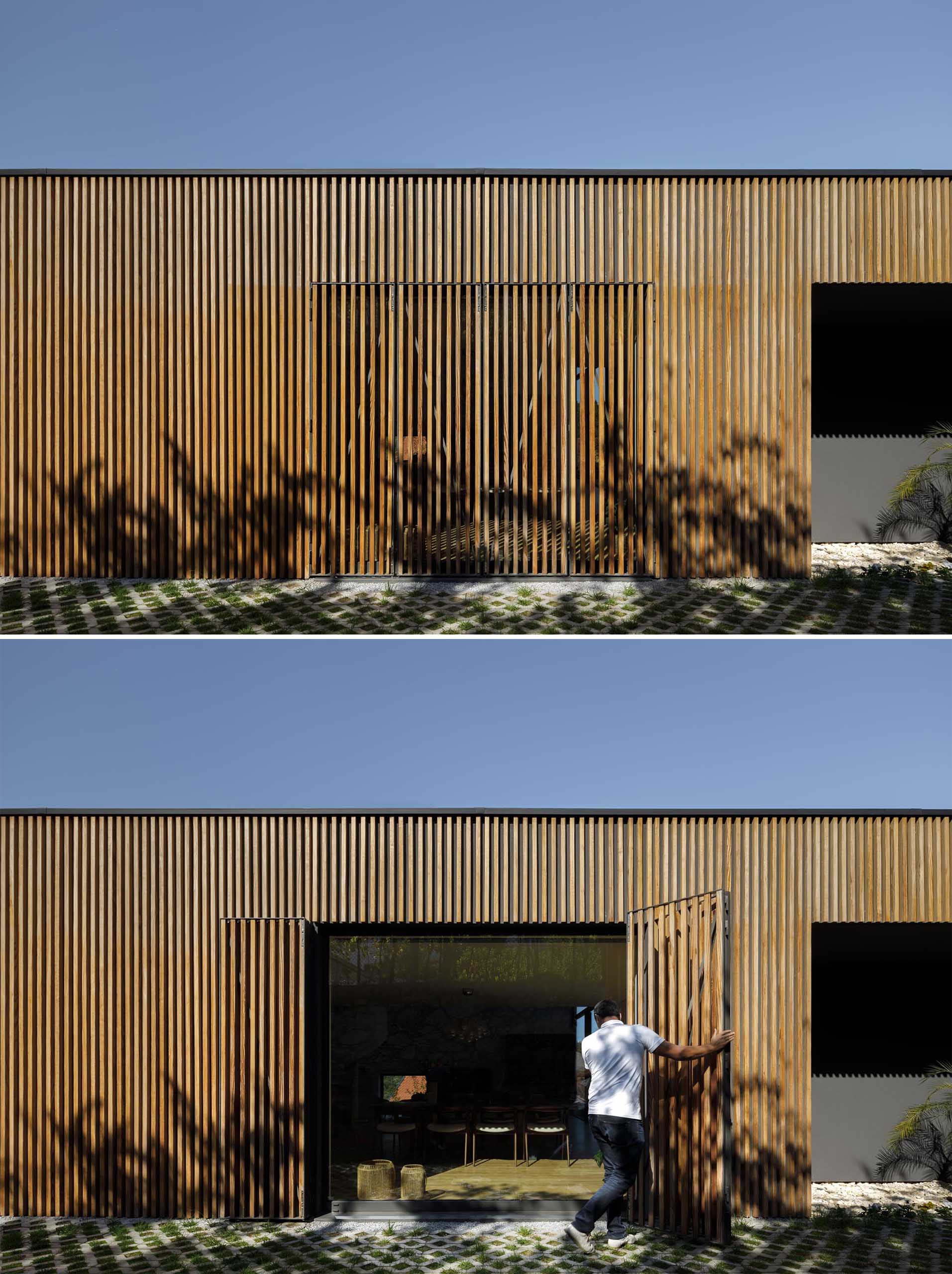 A modern home with a large window from view with a wood slat wall.