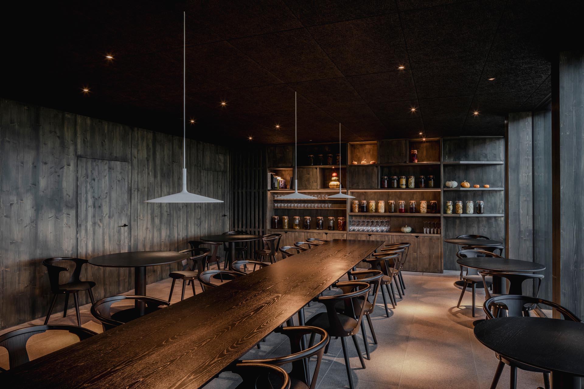 A modern hotel restaurant with a dark wood interior.