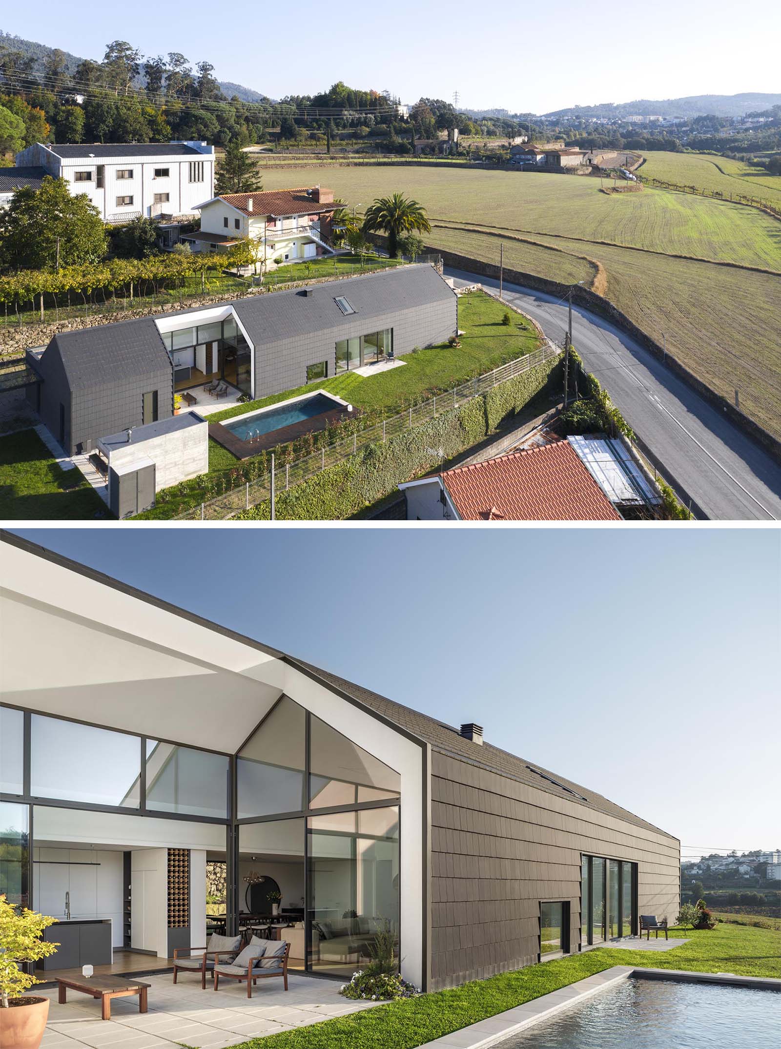 A modern house with a black exterior, and a void lined with glass and white walls.