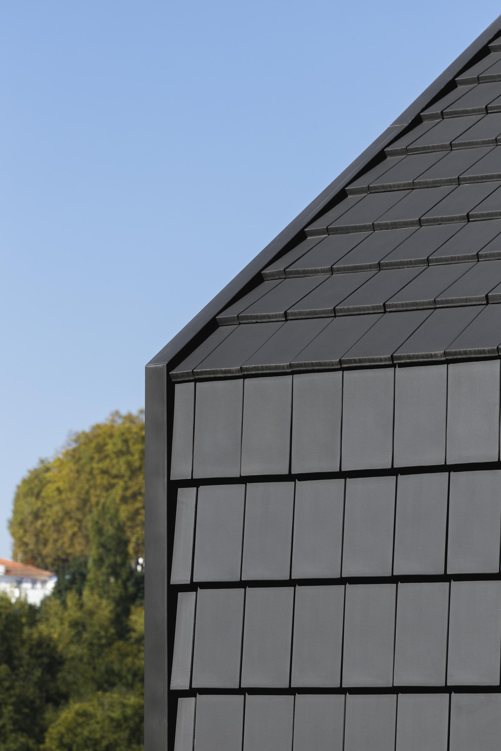 A modern house with black shingles.