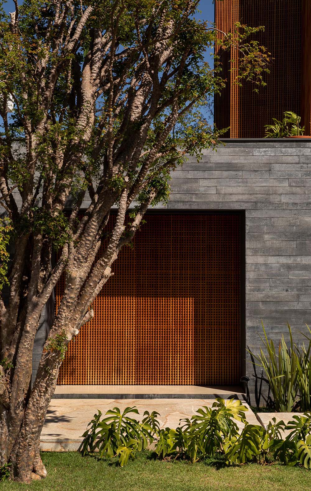 A modern home with a front door that blends into the wood accent.