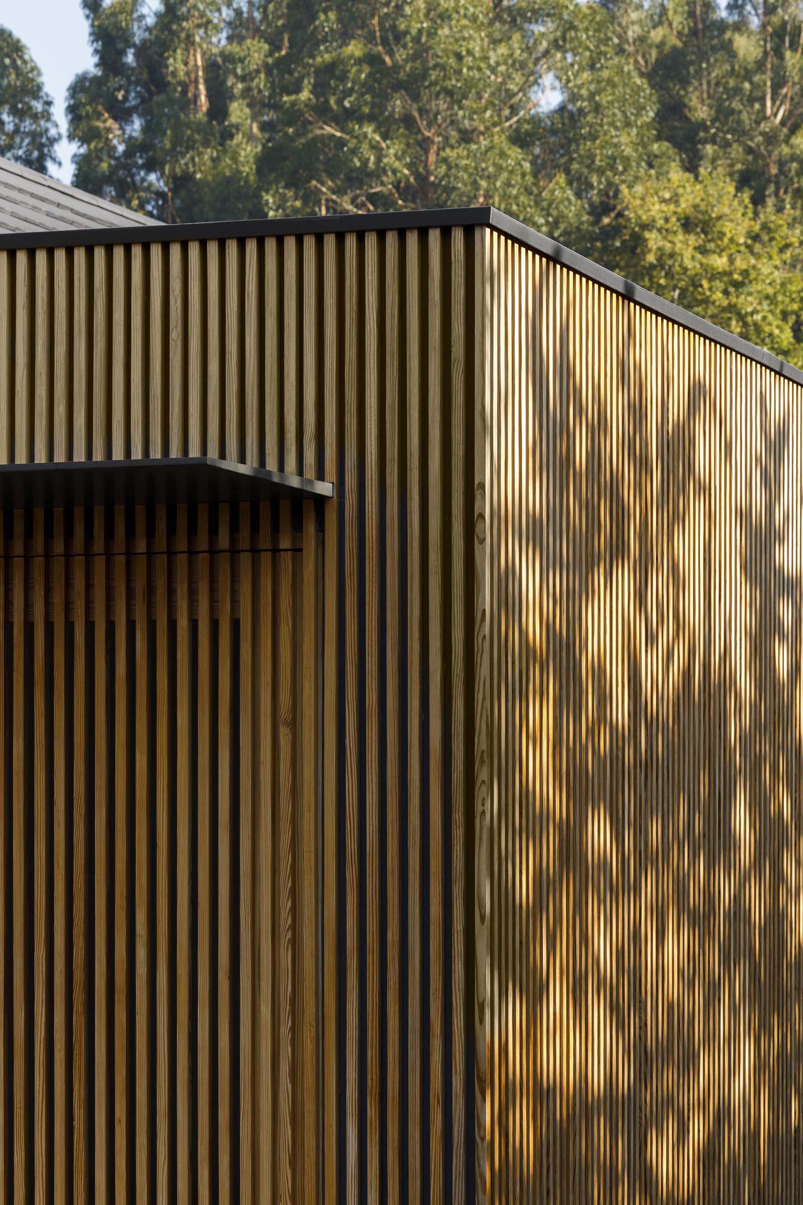 A modern house with a wood slat exterior and an integrated door.