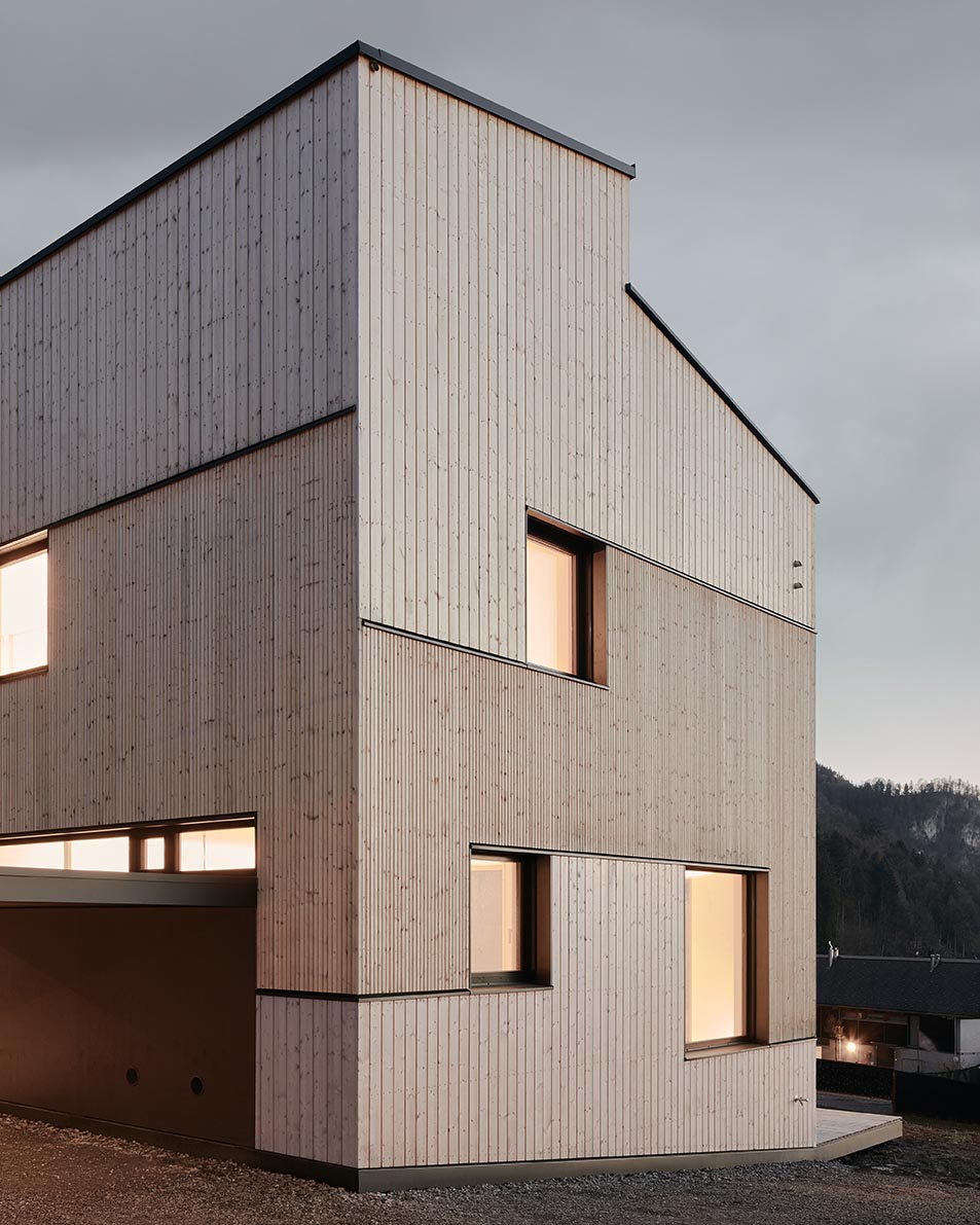 A modern wood duplex with different sizes of natural wood siding and black accents.