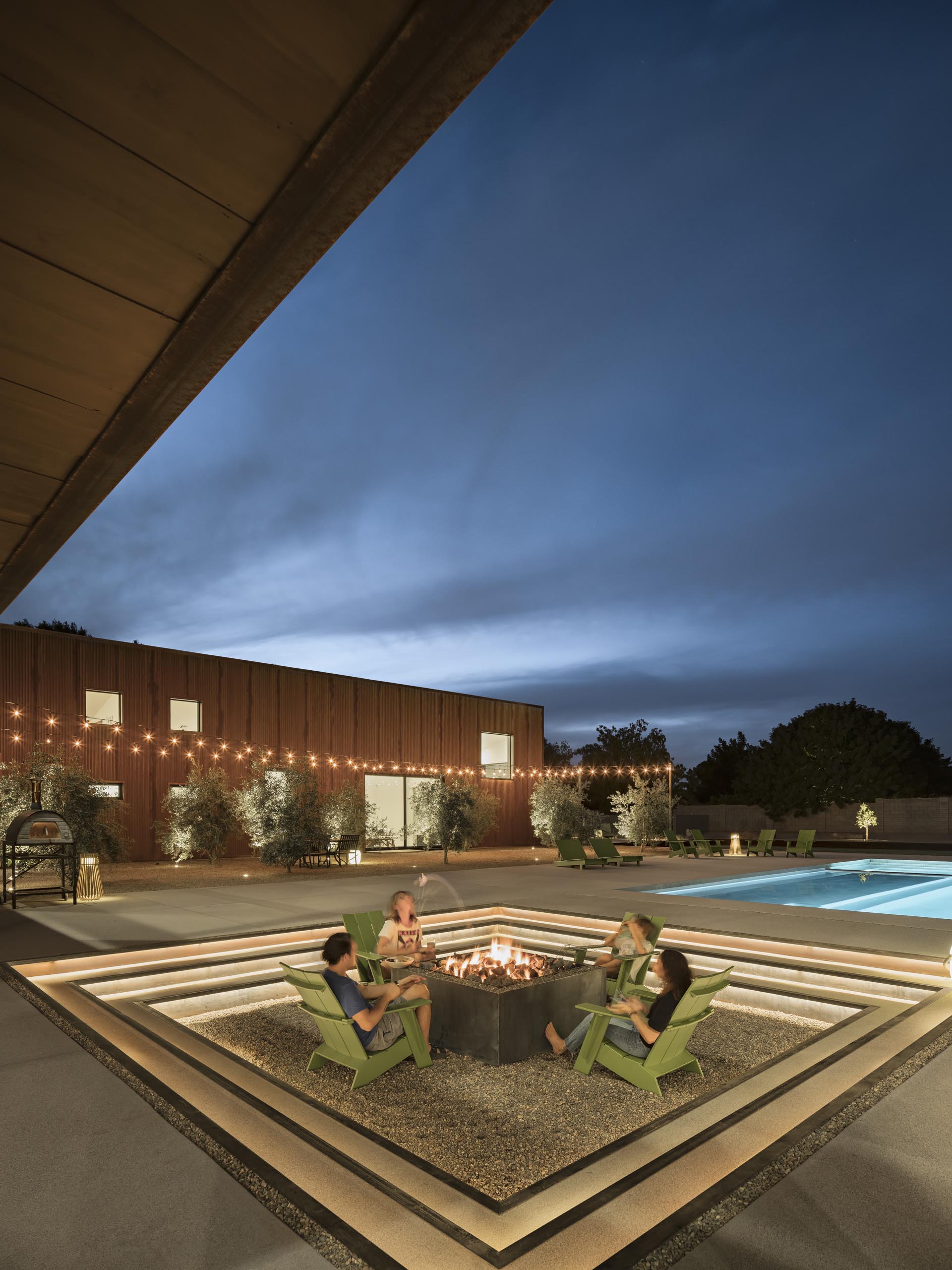 At night, the steps of this modern sunken fire pit are highlighted with hidden lighting, making the perfect place to relax on a cool evening.