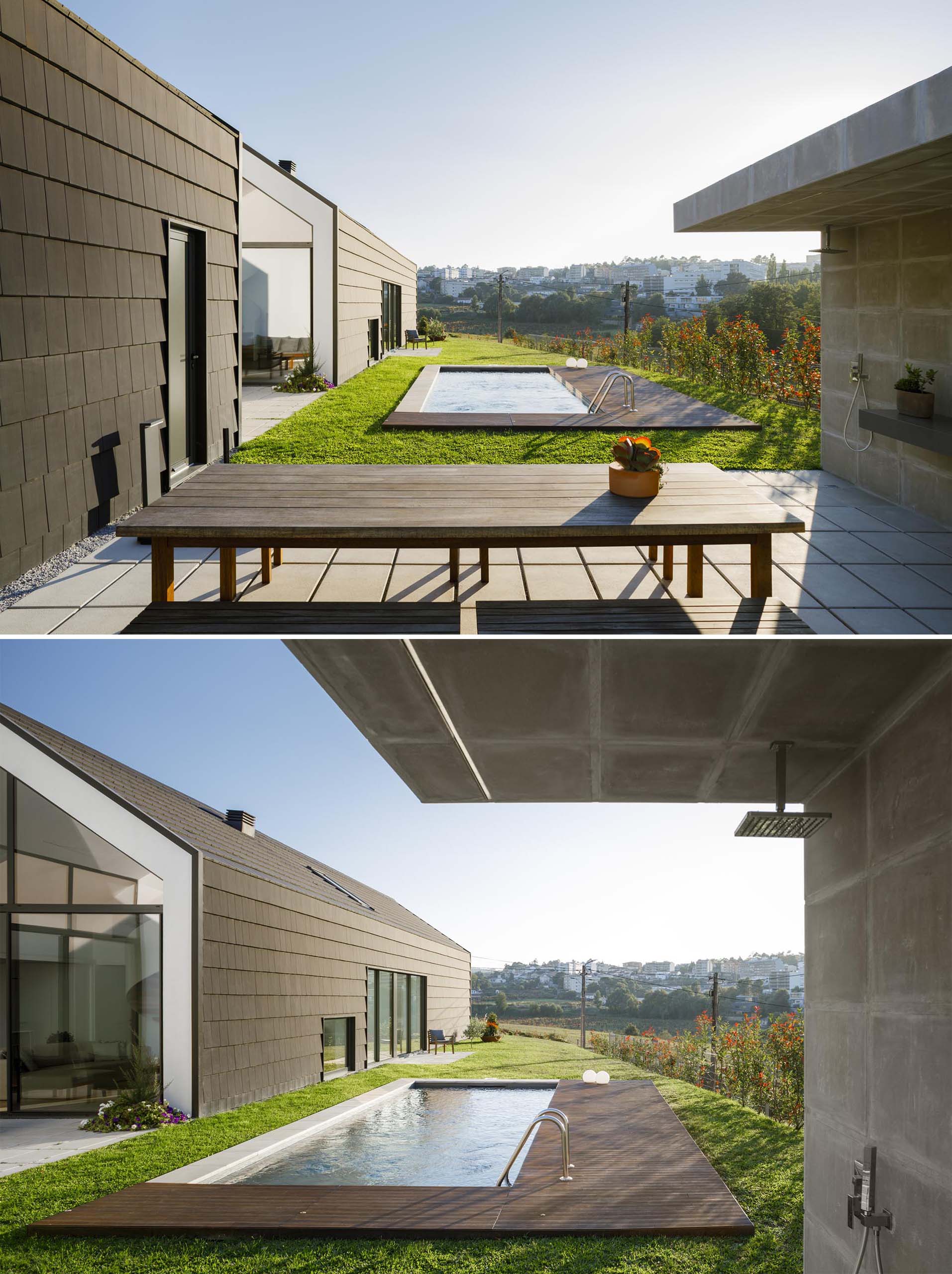 A modern swimming pool with a partial wood deck and an outdoor shower.