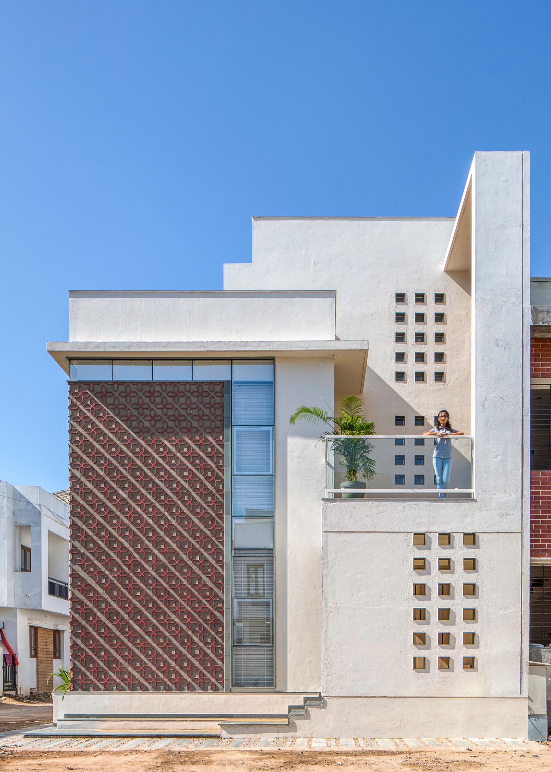 A modern house design with a unique patterned accent wall on its facade.