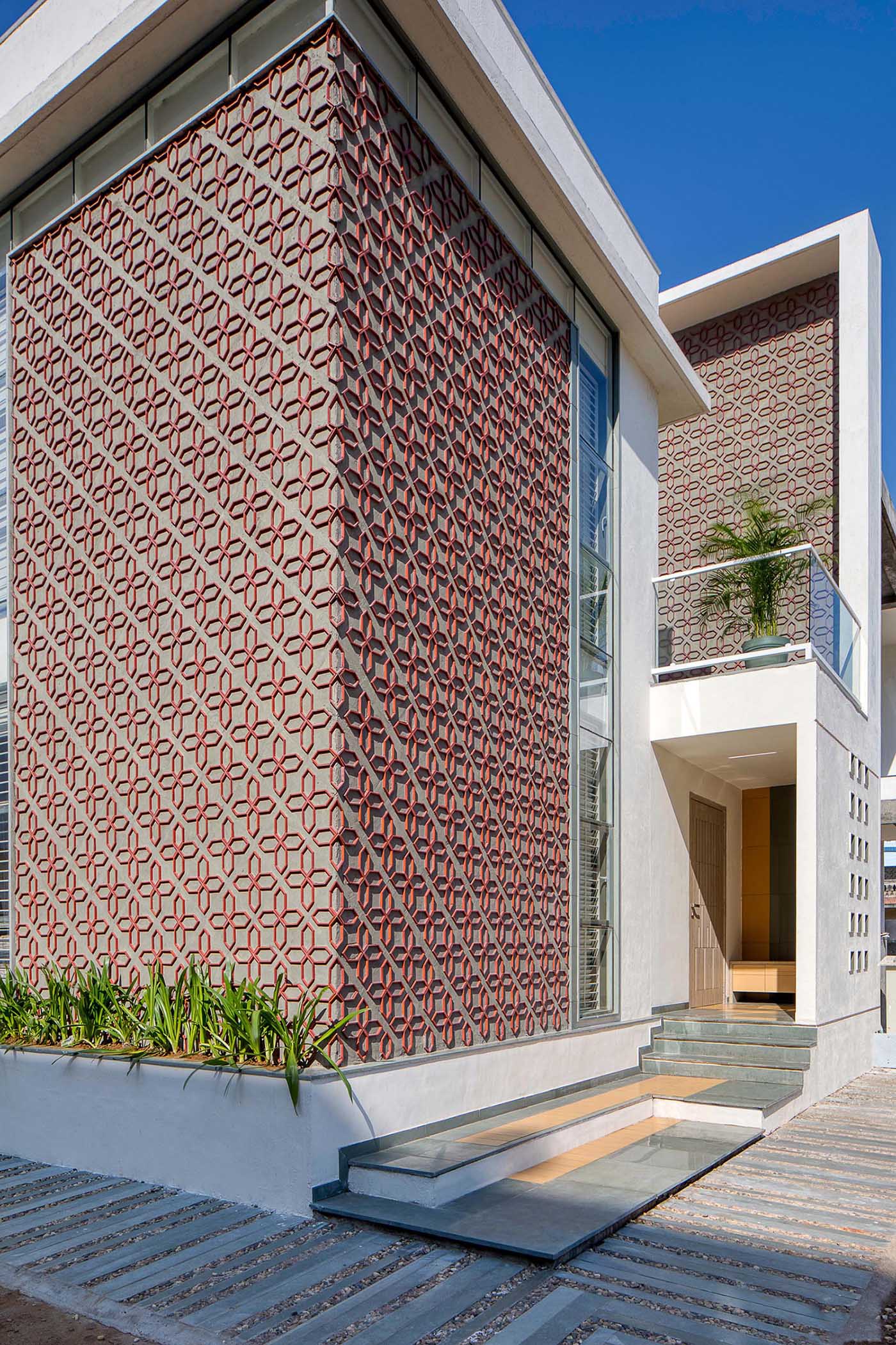 A modern house design with a unique patterned accent wall on its facade.