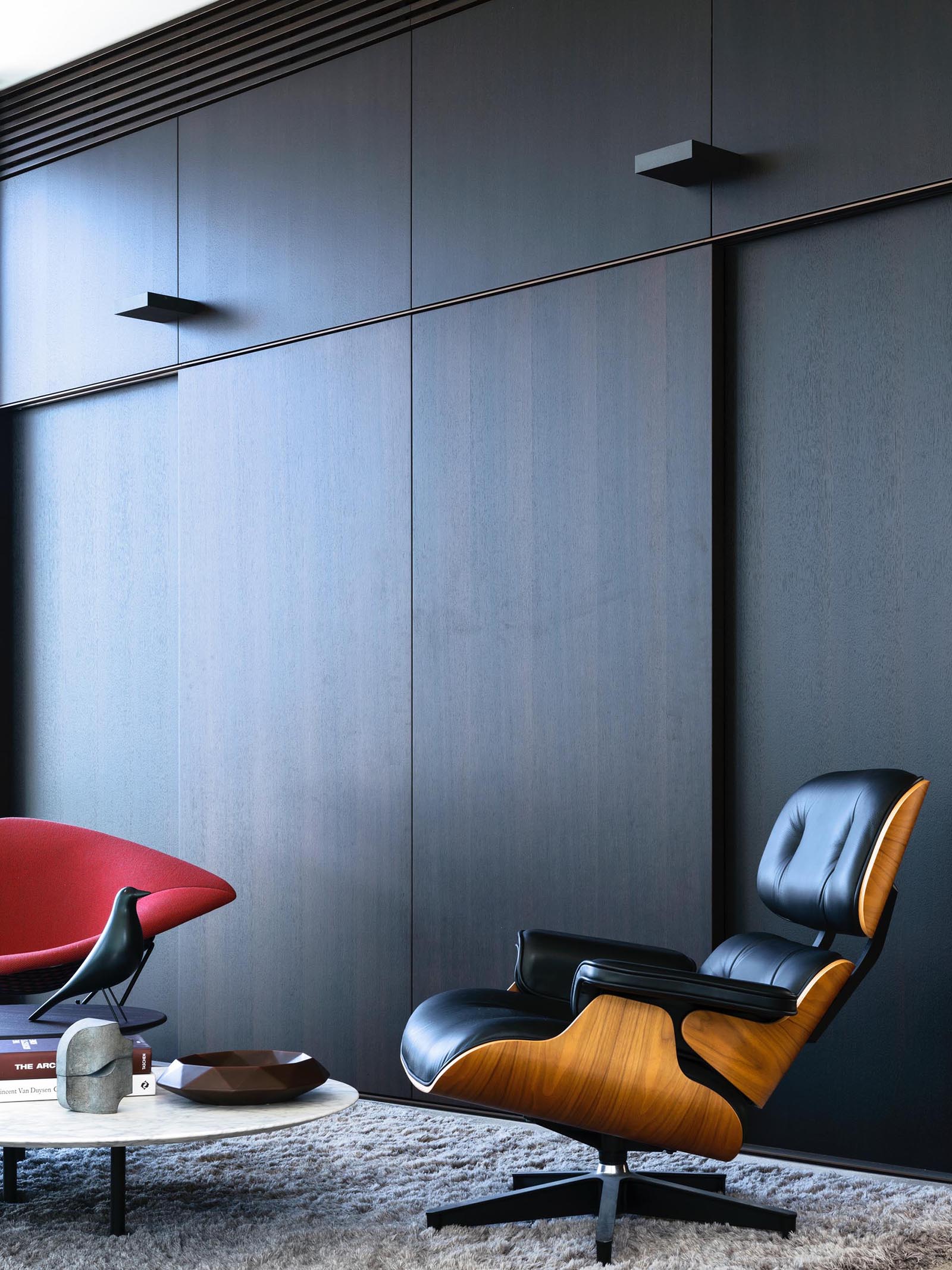 A modern living room with dark wood walls.