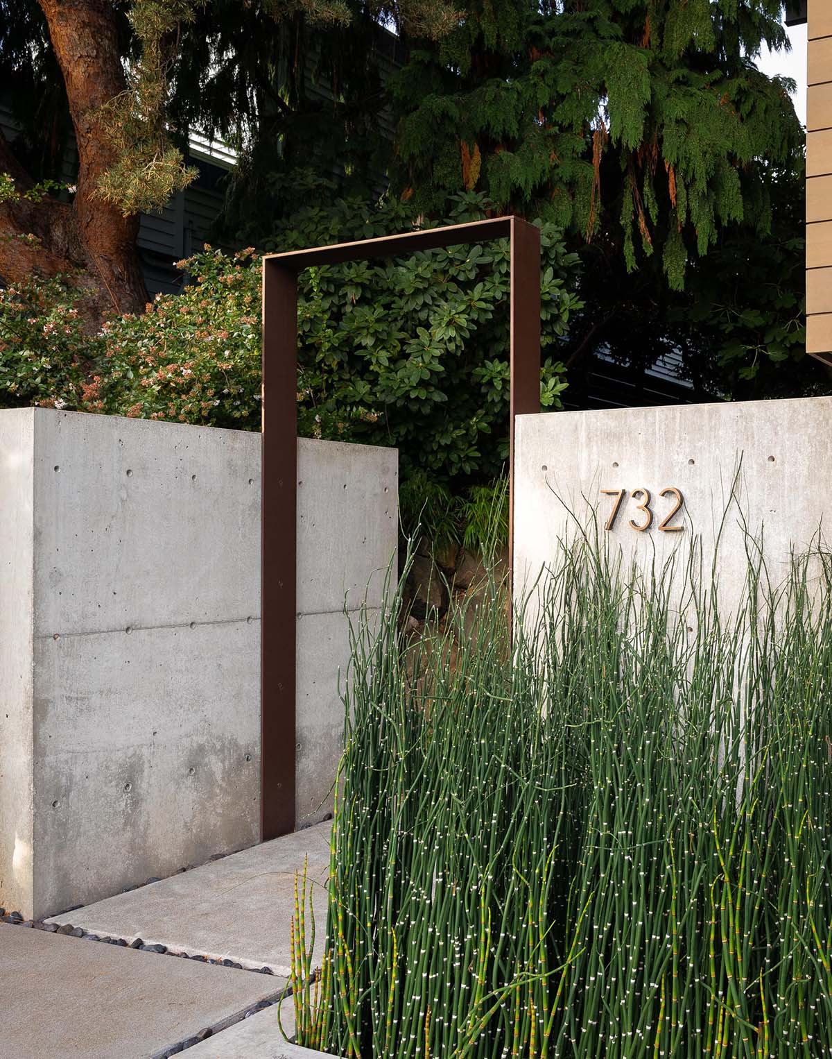 A modern house with a concrete wall and steel accent.