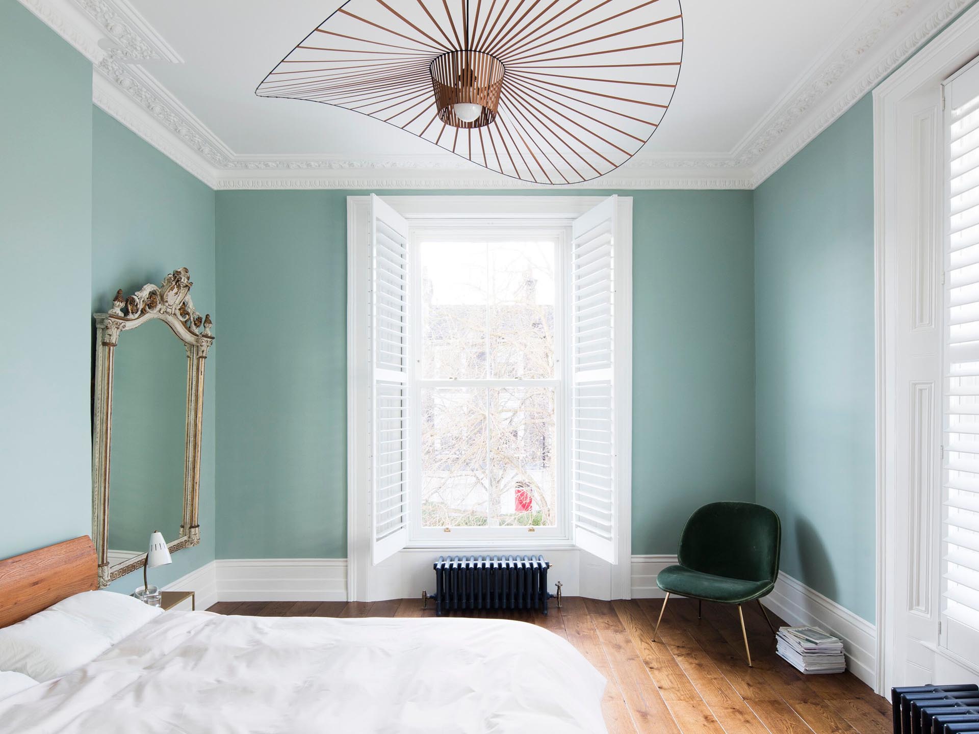 In this bedroom, traditional elements have been paired with modern touches, like light fixtures and furniture.