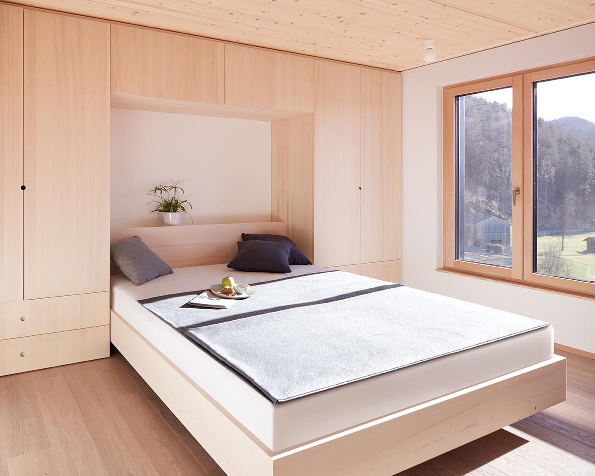 In this bedroom, built-in closets and drawers flank either side of the bed.