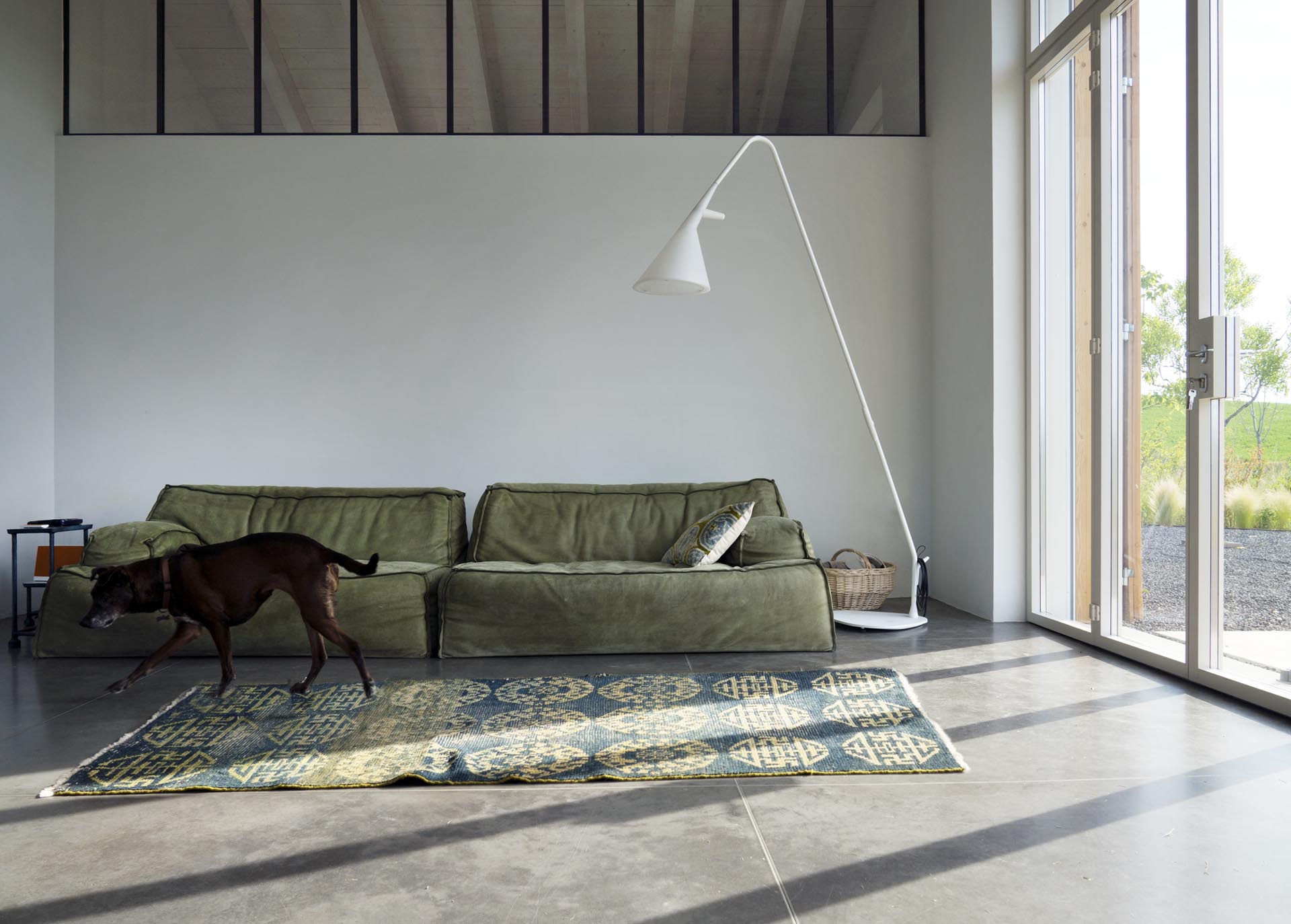 A modern farmhouse living room with white lime tempera walls and concrete floors.