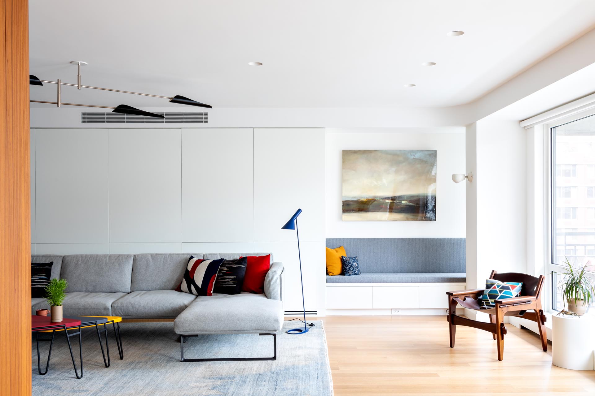 This modern apartment has a built-in bench that takes advantage of a small alcove by the windows.