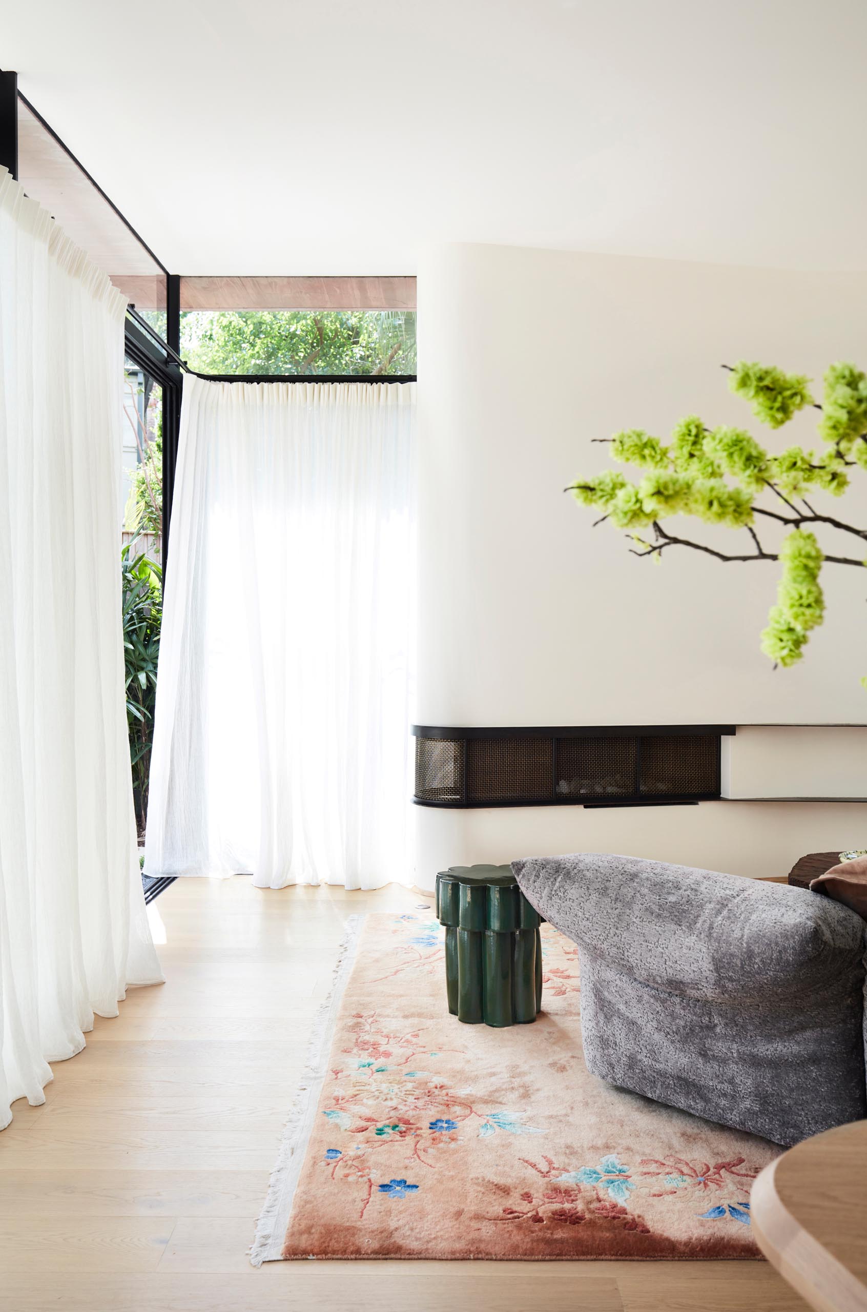 This modern living room is focused on the curved white wall with a built-in fireplace.