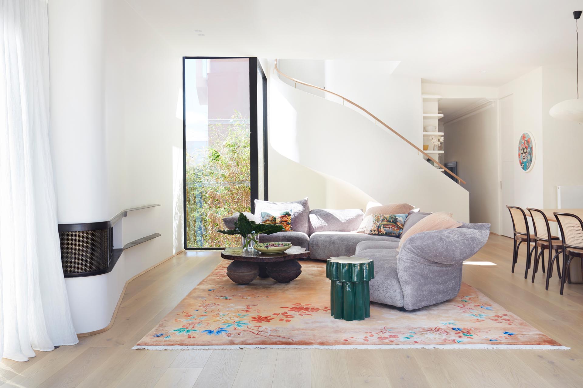 This modern living room is focused on the curved white wall with a built-in fireplace.