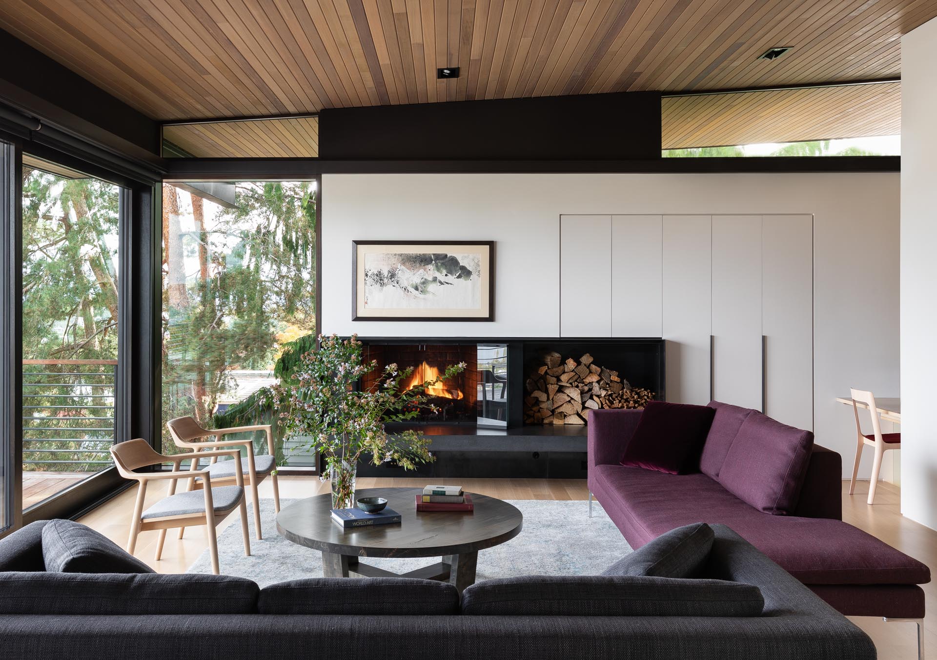 In this modern living room there's a fireplace and clerestory windows.