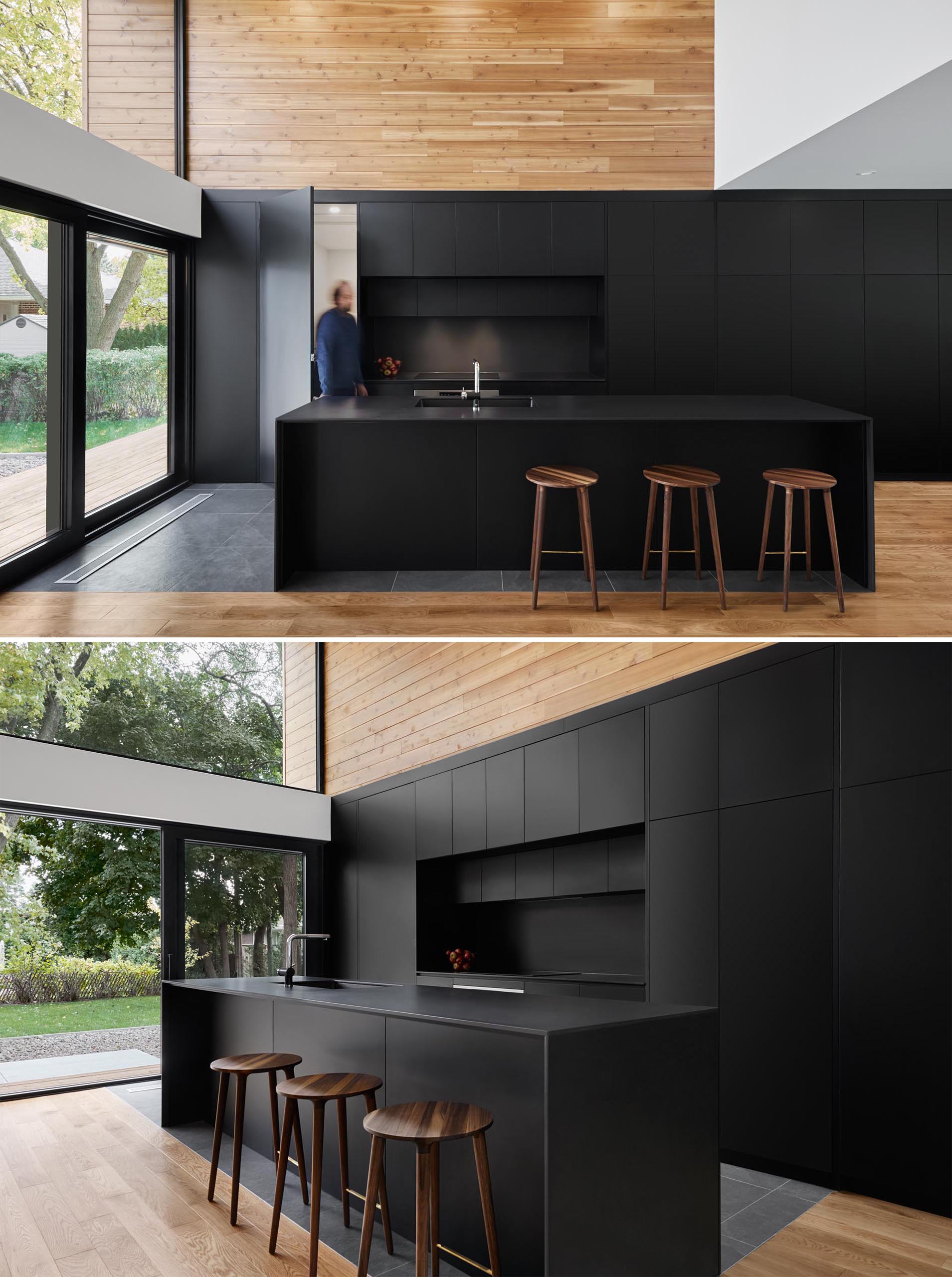 A modern matte black kitchen with integrated appliances and black countertops.