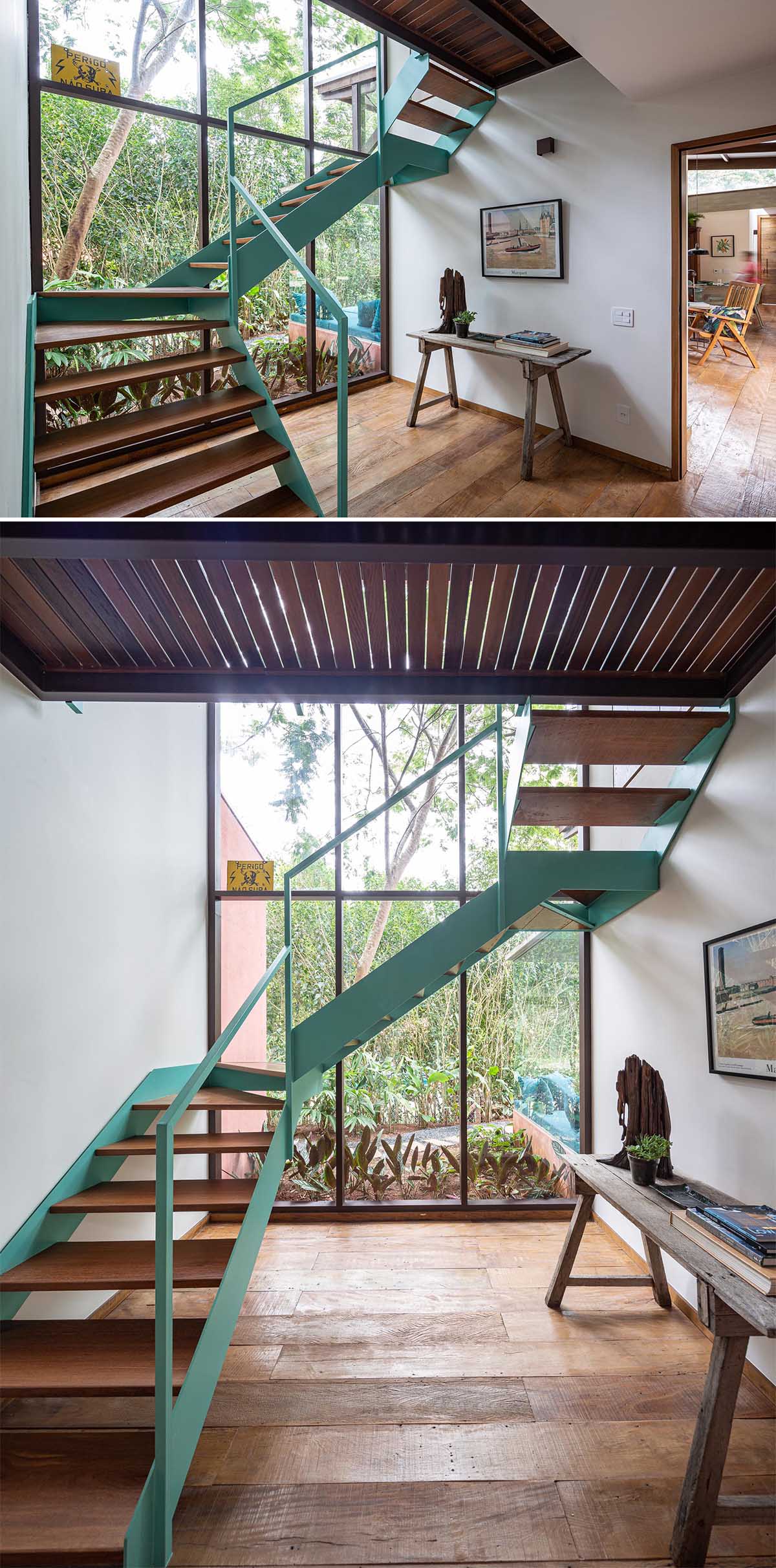 A staircase with a light turquoise blue frame and wood treads connects the two levels of the home.