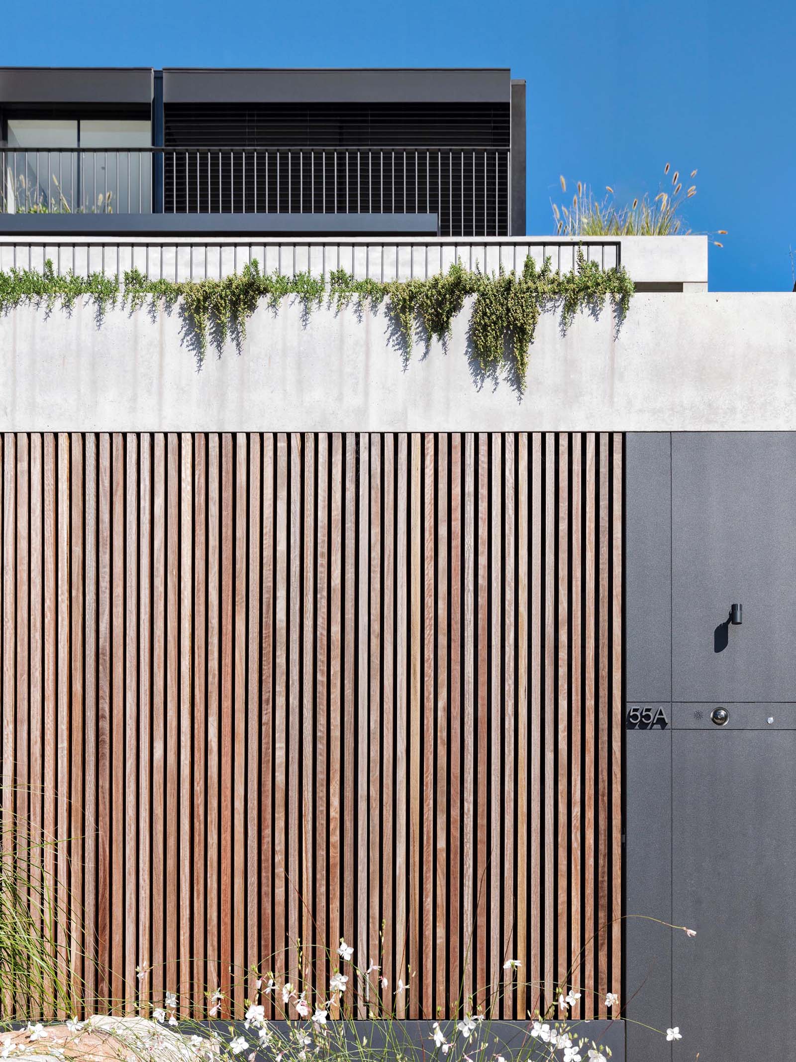 This Australian home is designed with a series of terraced floors that climb the steep block from the street.
