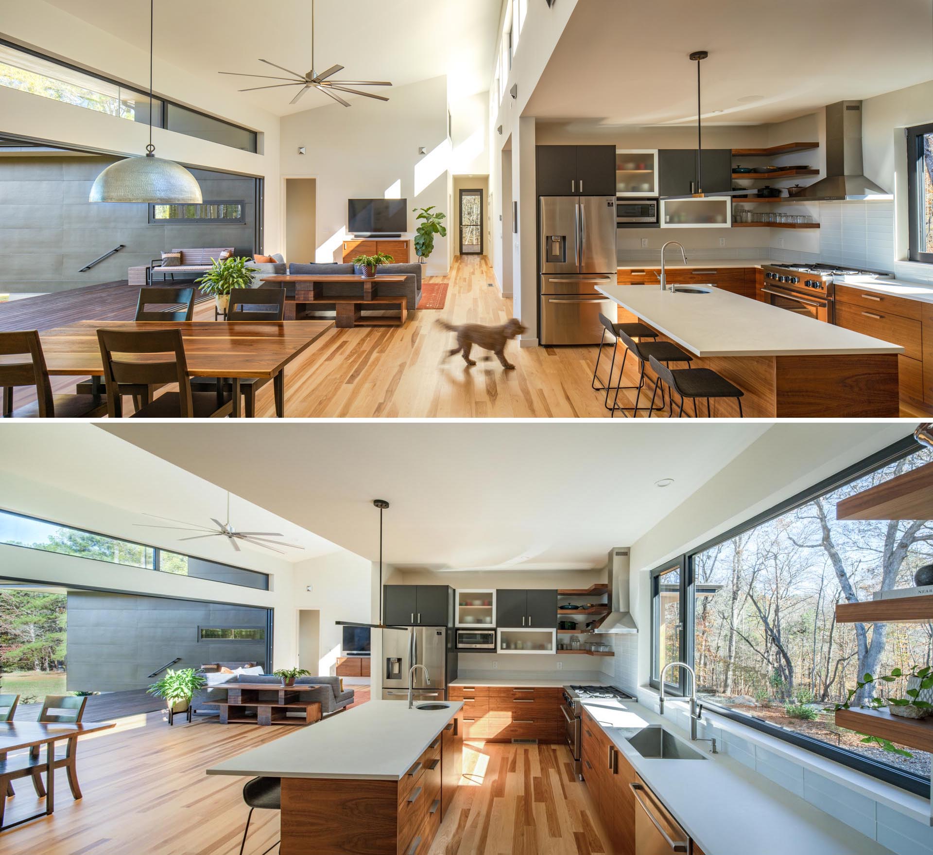 The kitchen in this modern home is adjacent to the living room and dining room, and includes an island with wood cabinetry and white countertops.