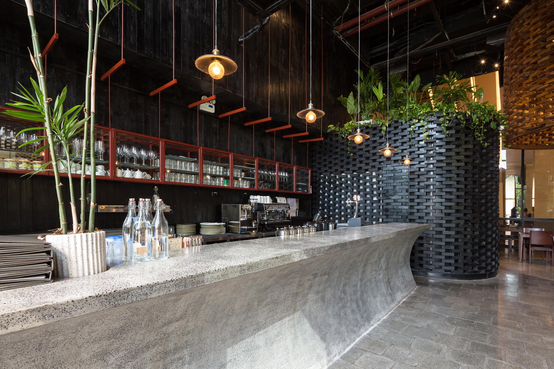 A modern restaurant with a curved concrete bar.