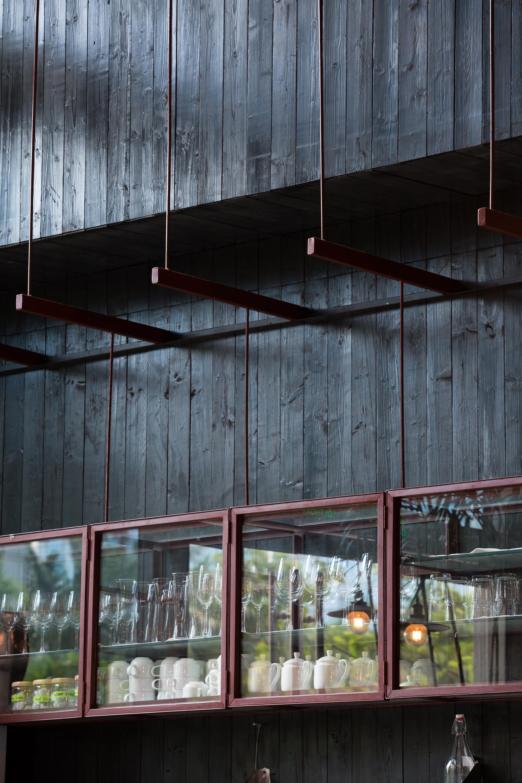 A modern restaurant with black wood walls and a glass display cabinet.