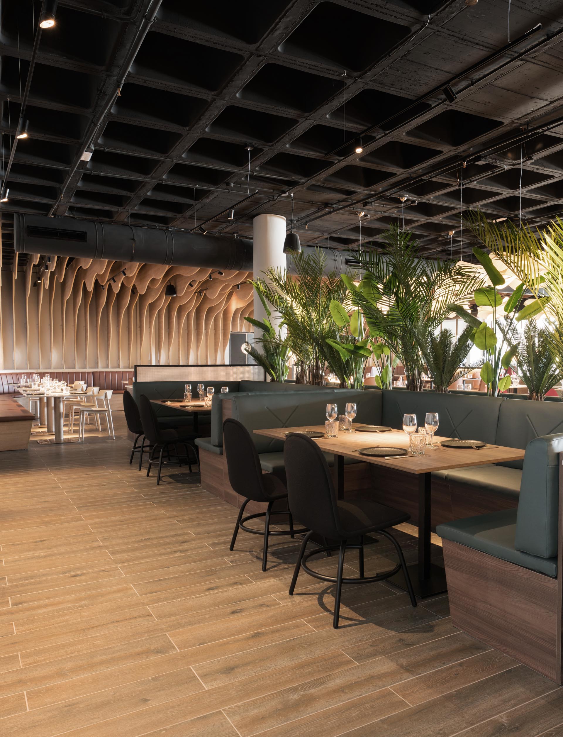 A modern restaurant with sculptural wood fins and black details.