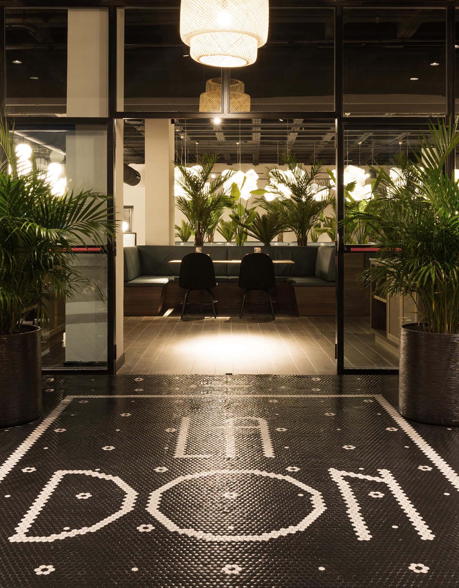 A modern restaurant with its name spelt out in black and white floor tiles.